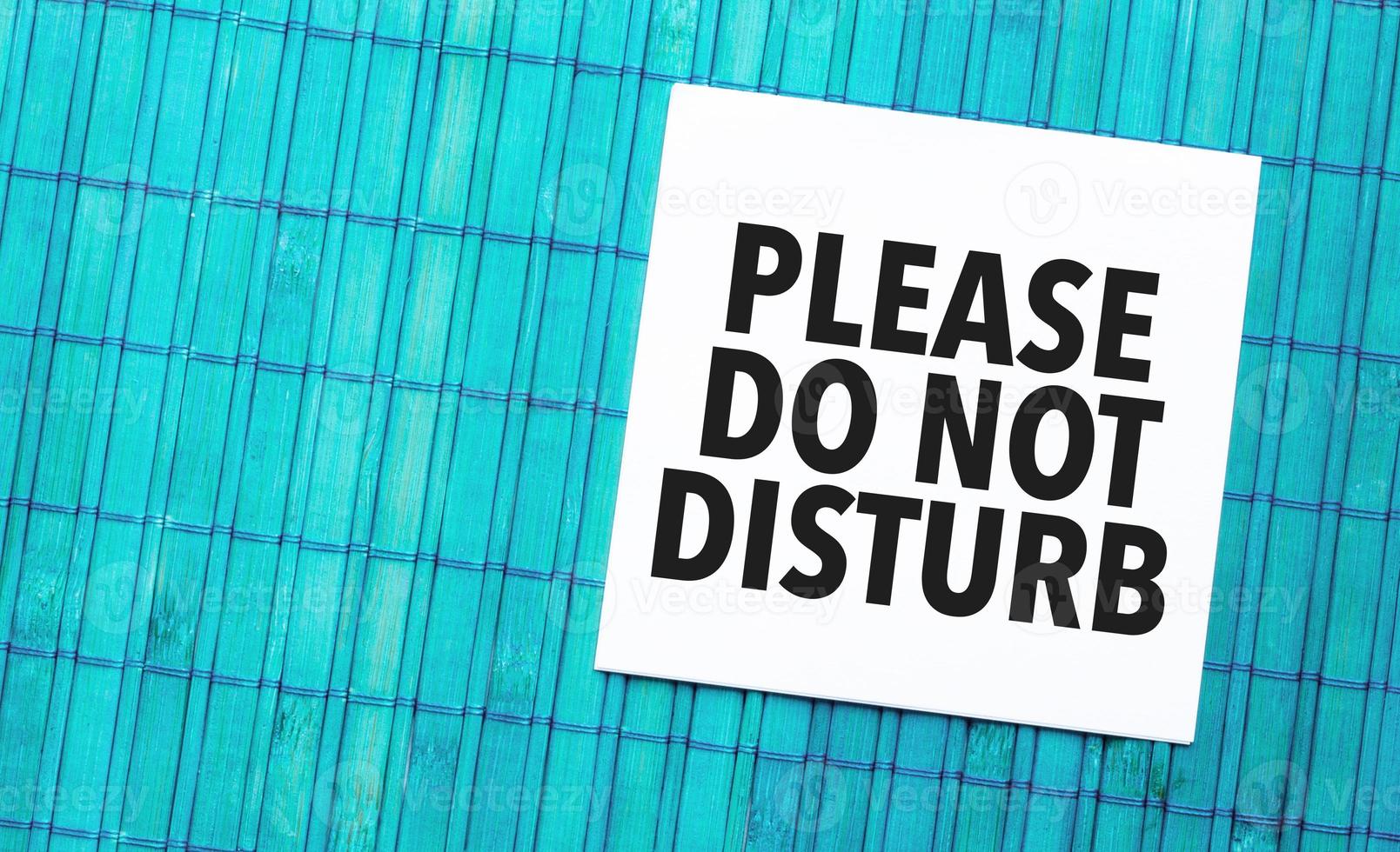 please do not disturb word on torn paper with blue wooden background photo