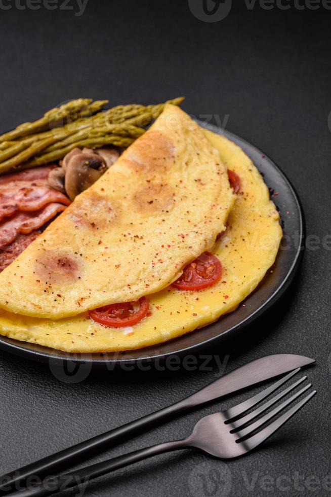 Delicious fresh omelet with cherry tomatoes, bacon, asparagus and spices photo