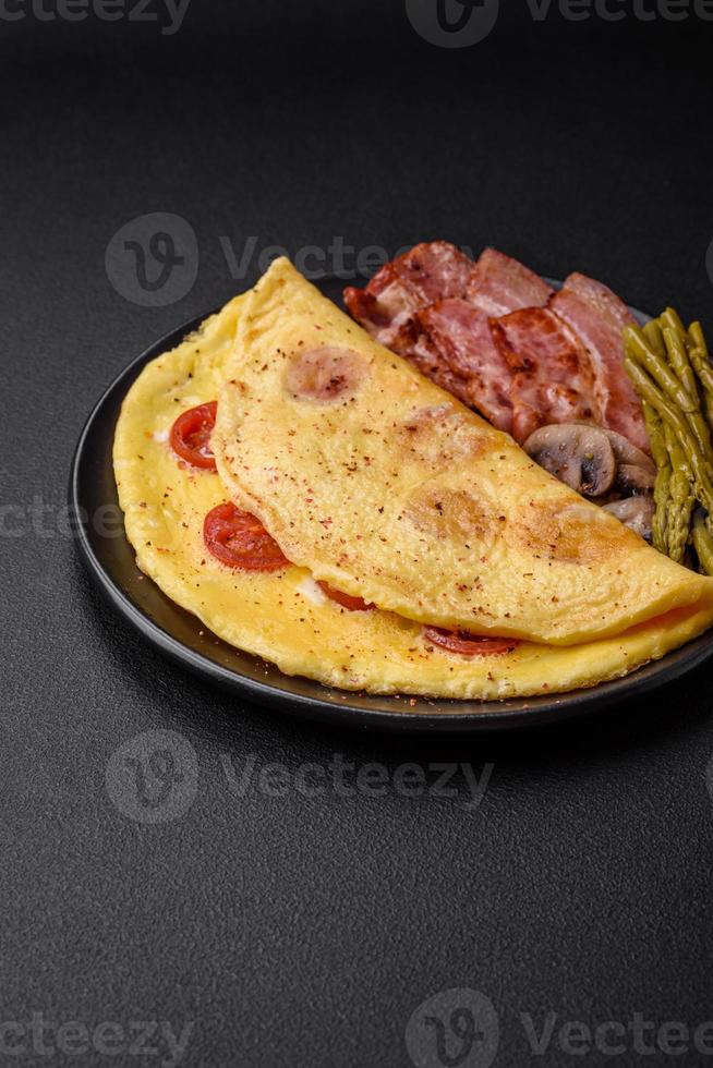 Delicious fresh omelet with cherry tomatoes, bacon, asparagus and spices photo