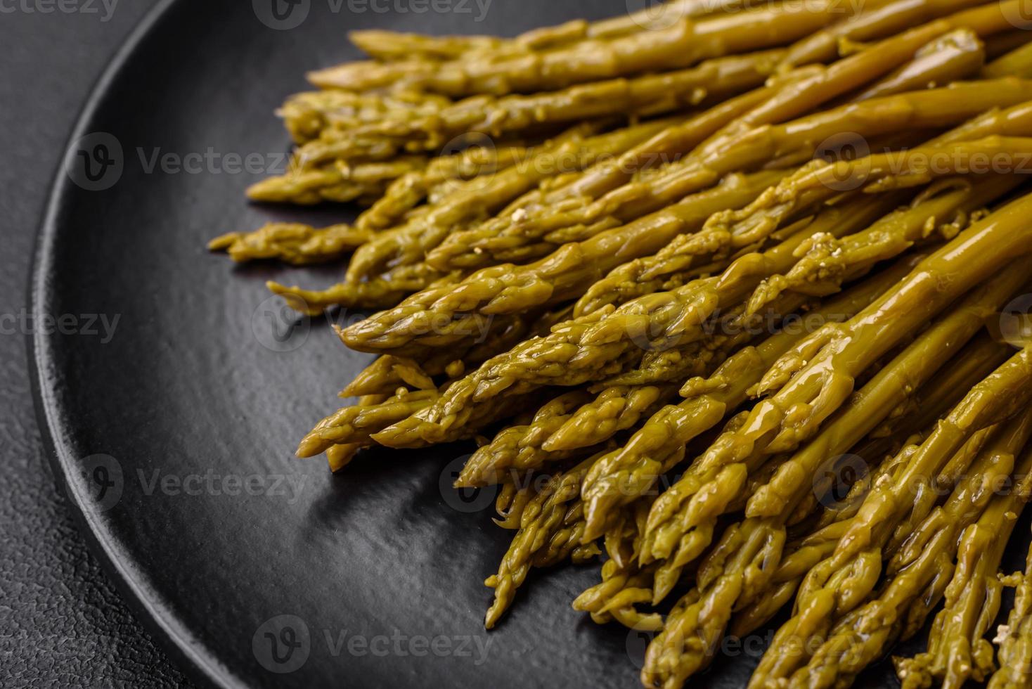 ramitas de delicioso Enlatado espárragos en un negro cerámico plato foto