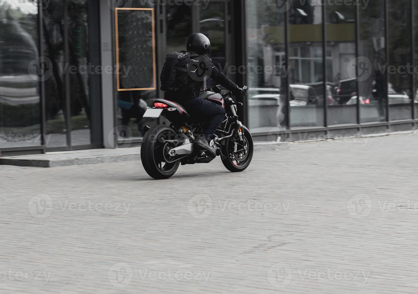 man wearing jeans and rides on motorcycle photo