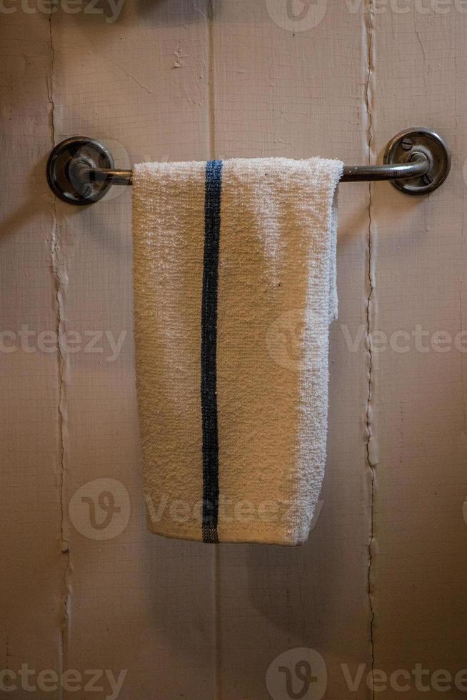 Towel hanging on a bar in a rustic bathroom photo