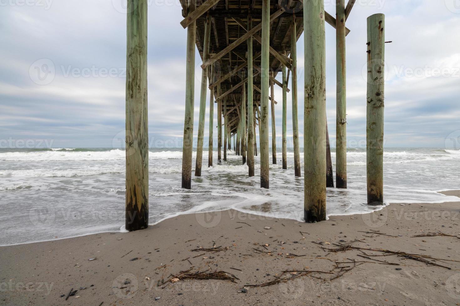 under an ocean pier at the beach photo