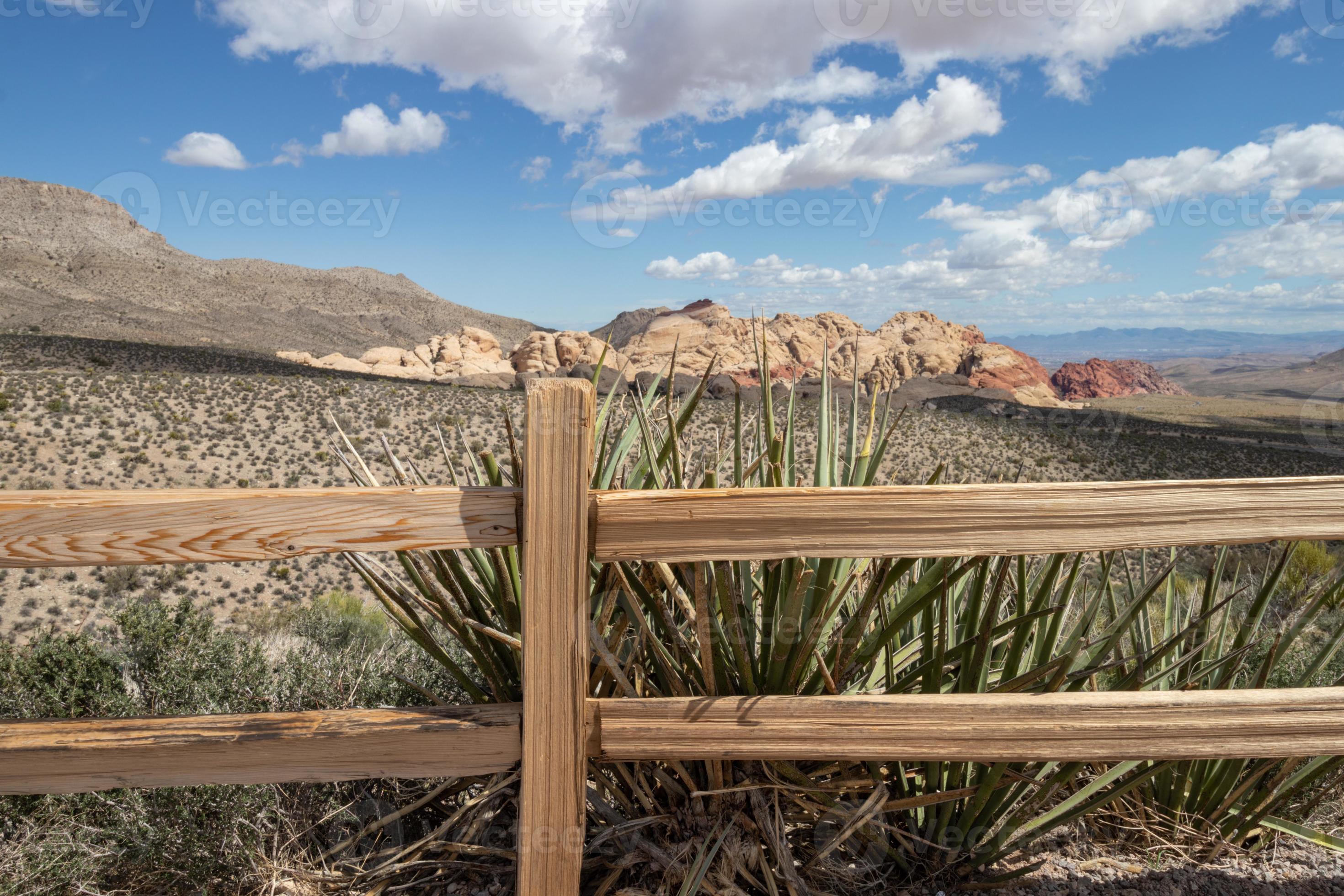 View of the mountains and desert from behind a wood rail fence in