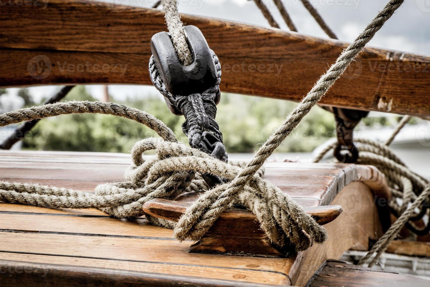 Pulley and lines on the deck of an old wooden sailboat photo