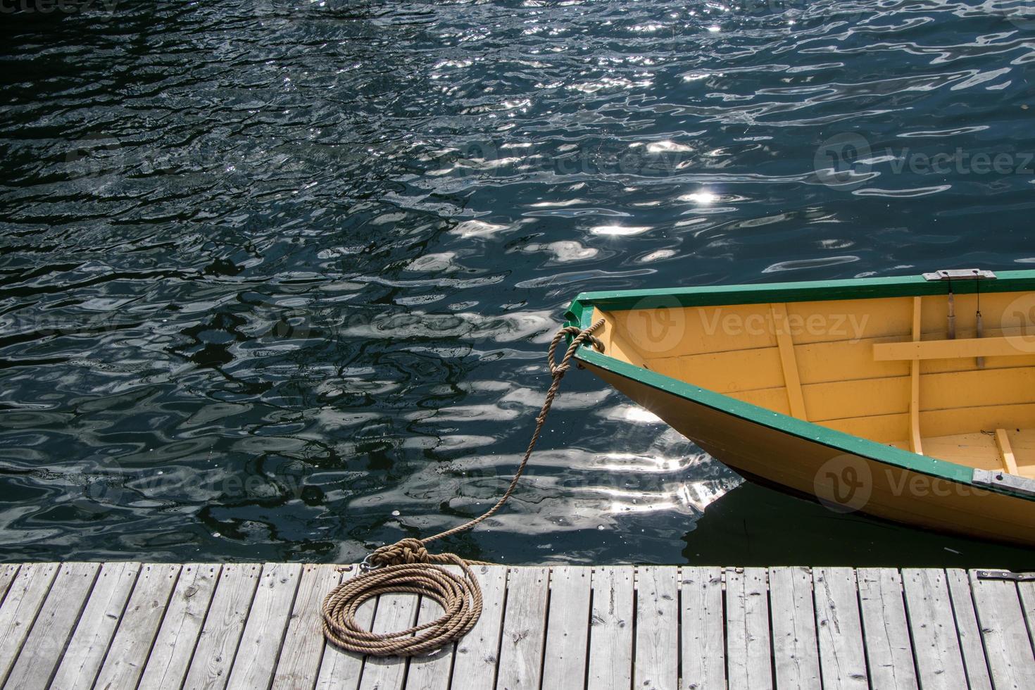 Small wooden boat tied to the dock photo