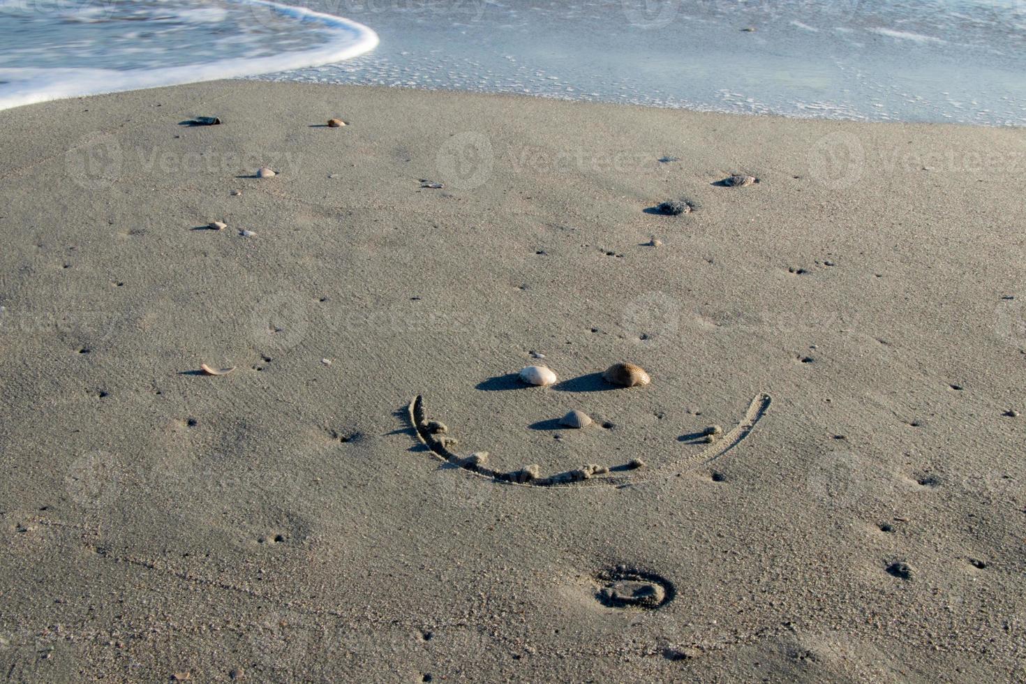 smily face in the sand at the beach photo