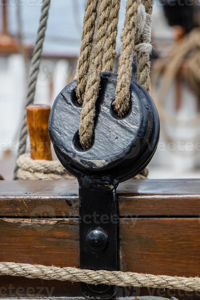 pulleys and ropes on a wooden sailboat photo