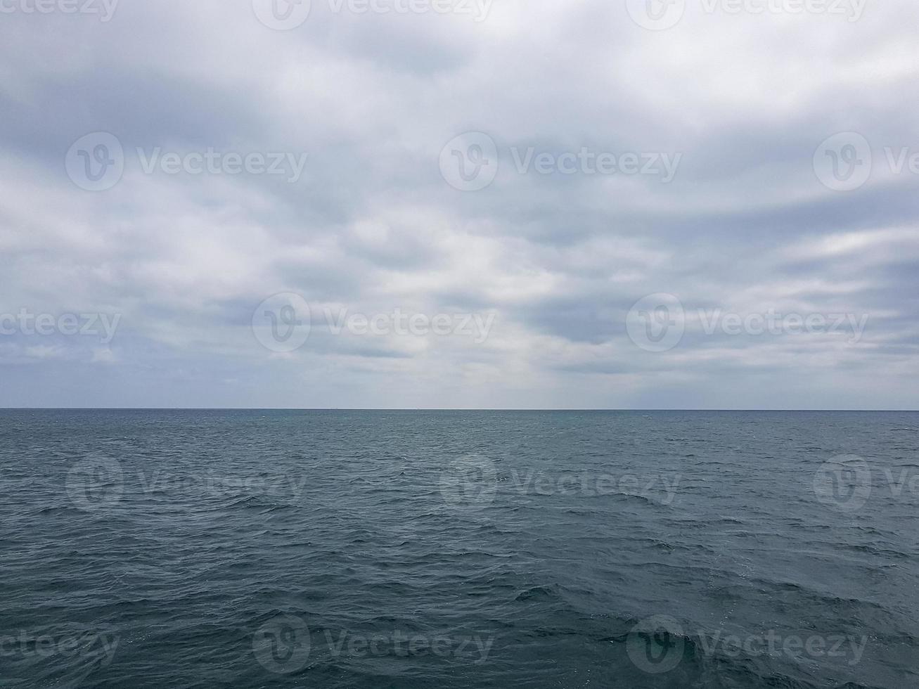 Seascape Sea with calm water and white clouds photo