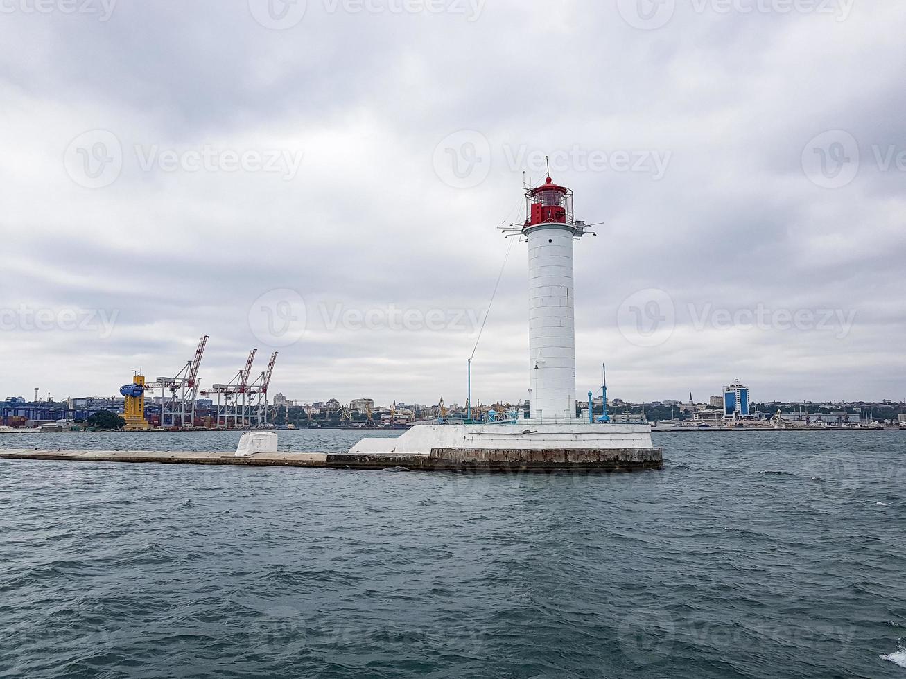 Seascape Sea with lighthouse, calm water and white clouds photo