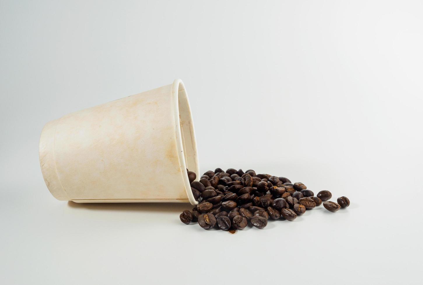 Roasted Arabica coffee beans, ready to make coffee that people like to drink. Placed in a white coffee cup paper on the background. Looks beautiful and appetizing. Drink. photo