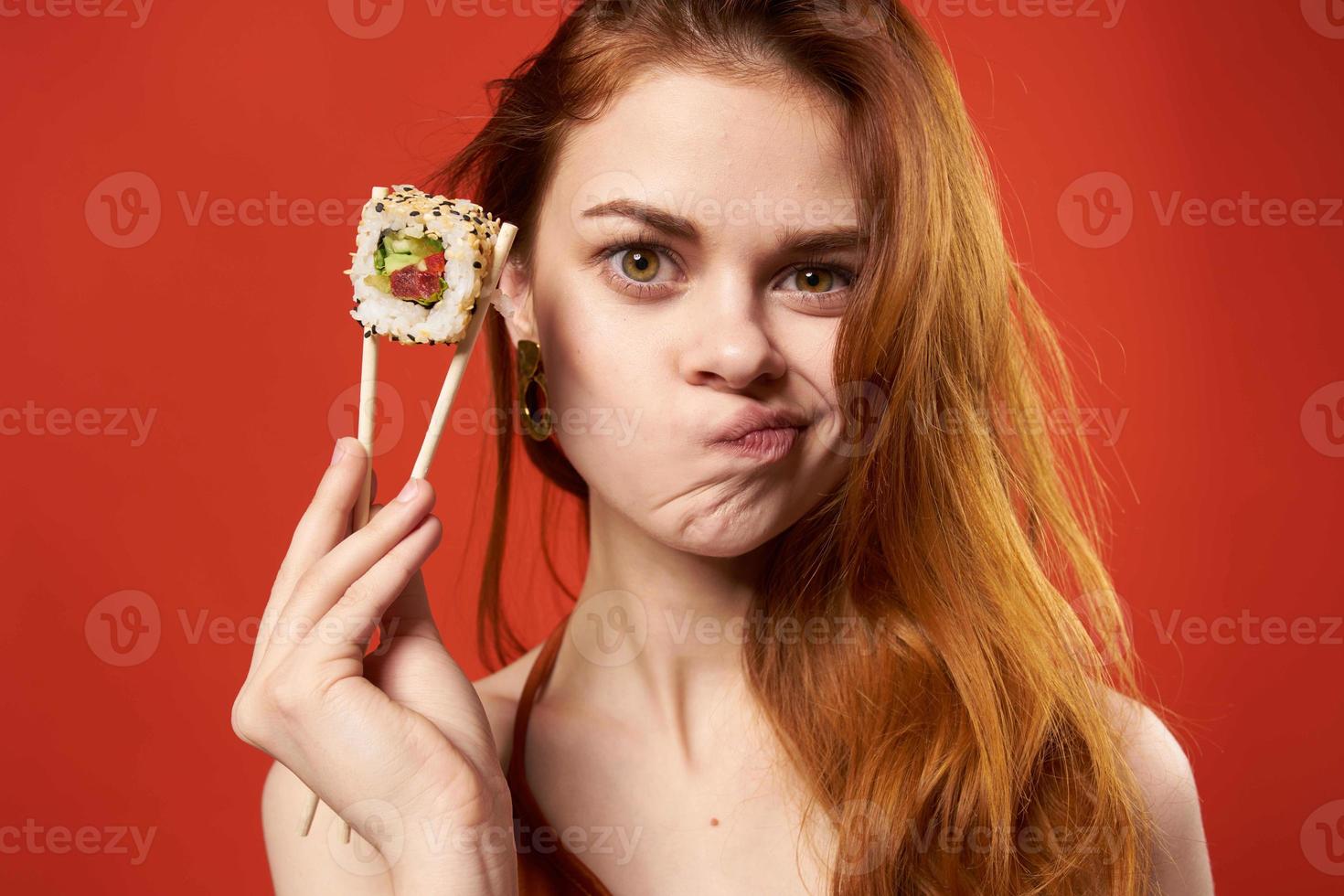 cheerful woman eating sushi asian food red background photo