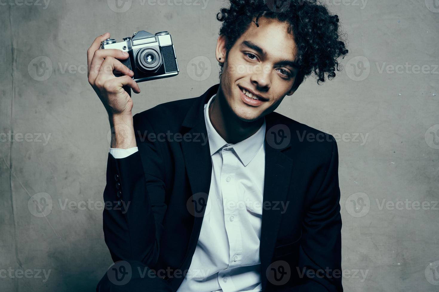 guy holding a camera in his hand retro classic suit curly model man photo