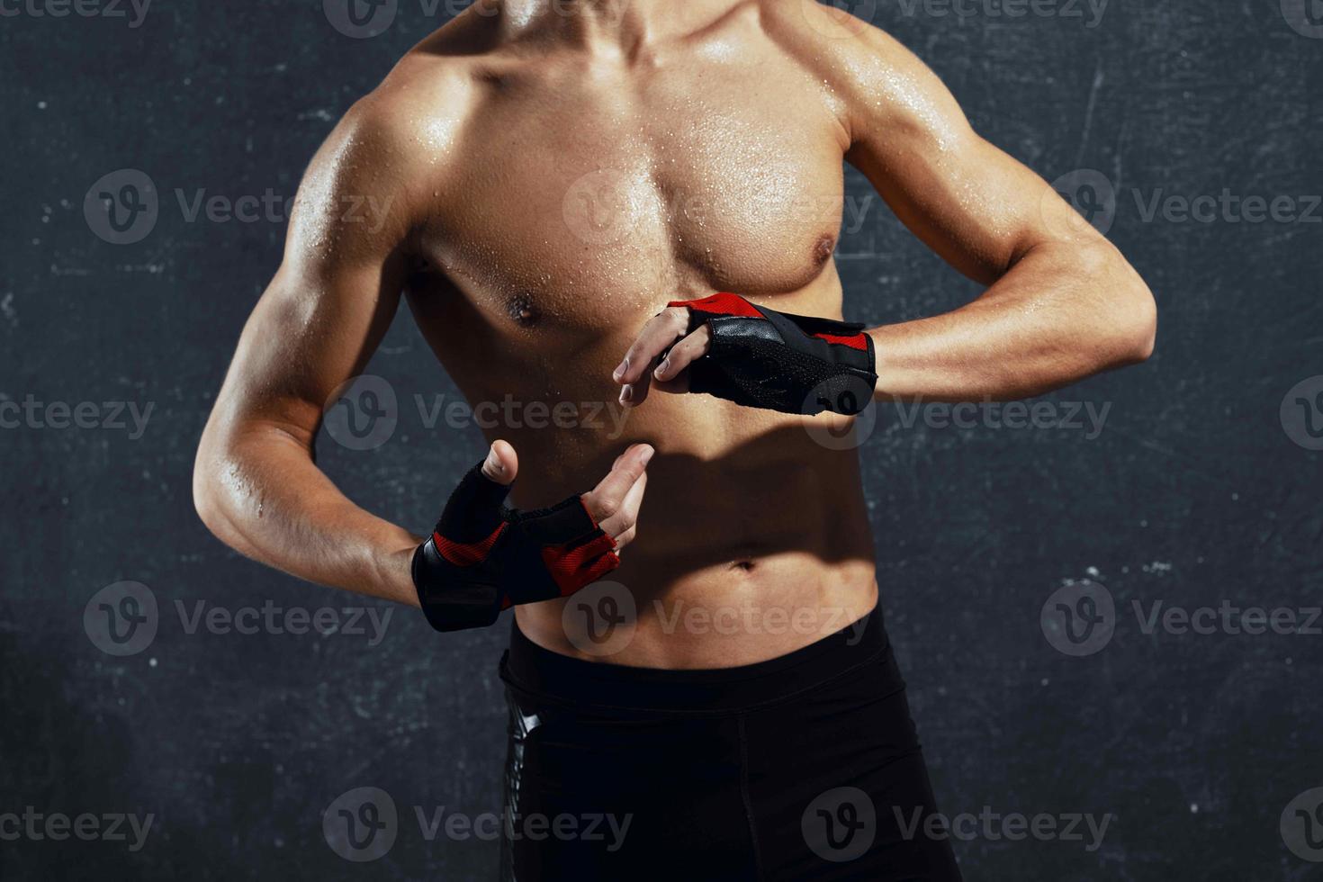 bodybuilder muscle press posing cropped view dark background photo