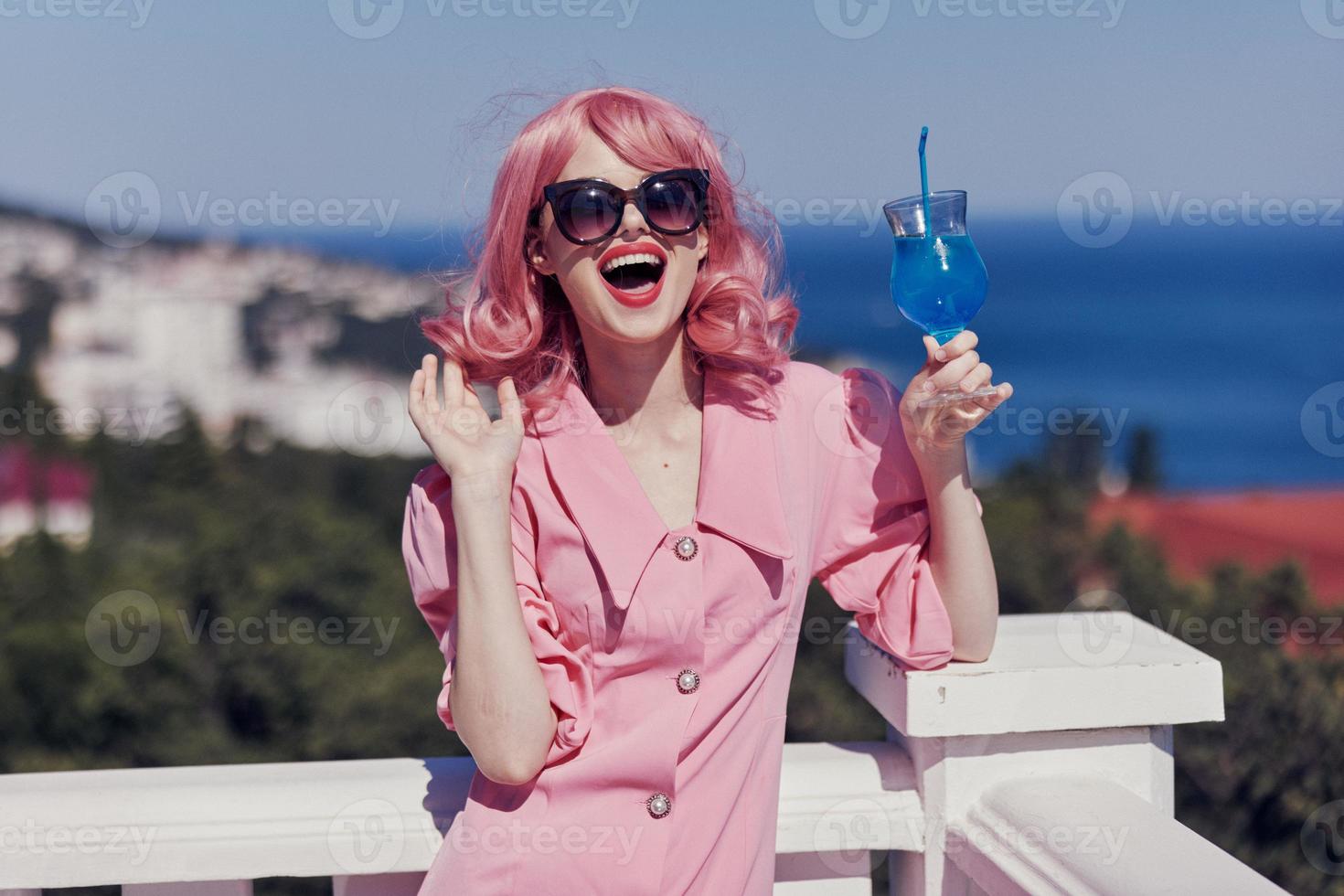 Young female in a pink dress in sunglasses with a cocktail sunny day photo