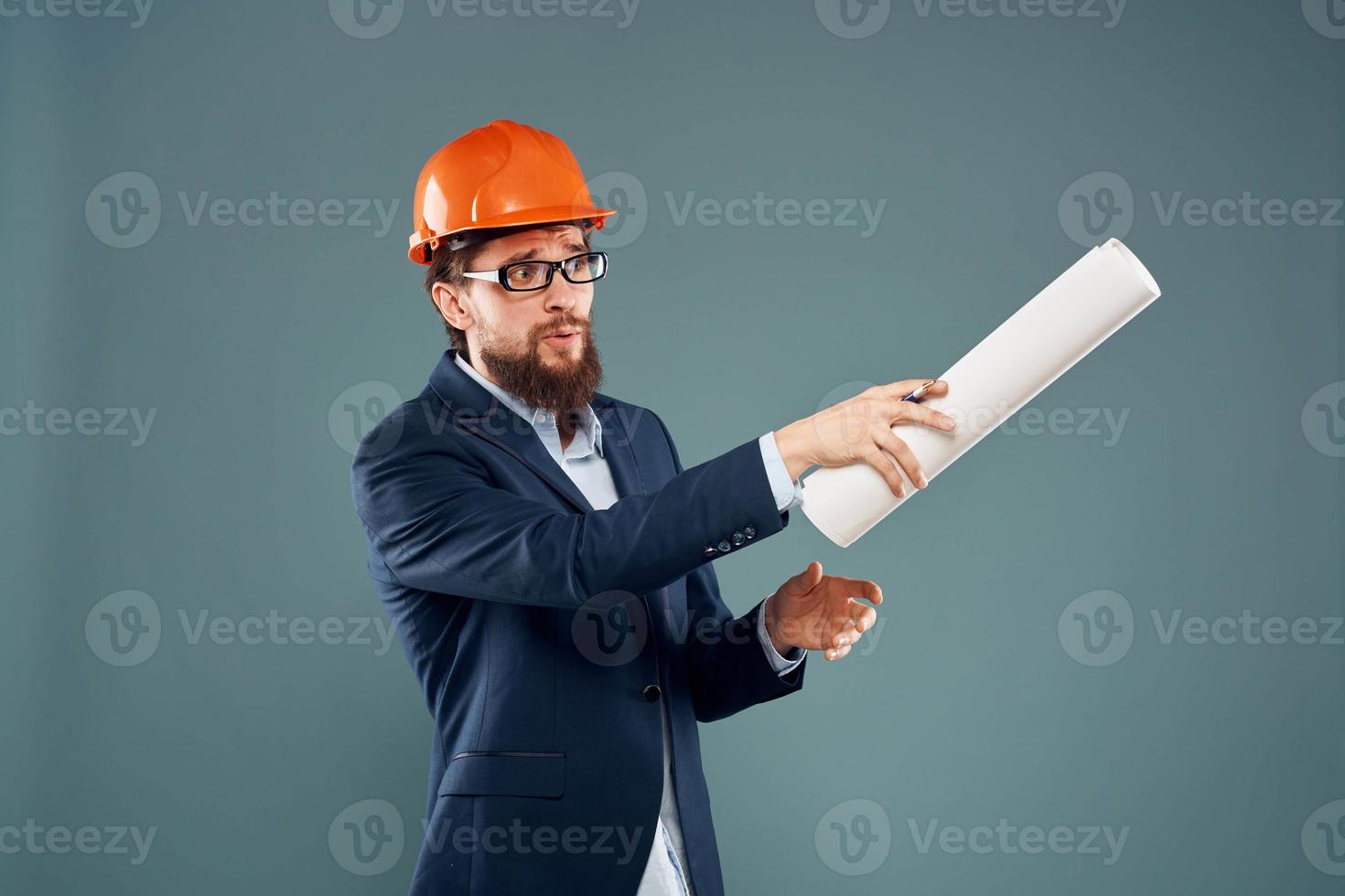 A man in a suit in an orange hard hat blueprints in the hands of a construction engineer photo