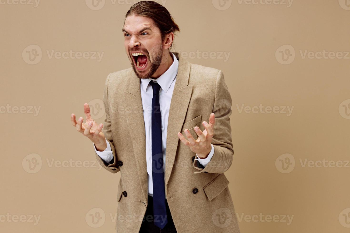man in beige jacket emotional man in suit gesture with hands beige background photo