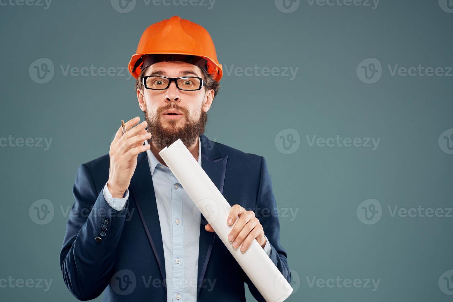 Male engineer wearing a suit in orange paint safety work drawings photo