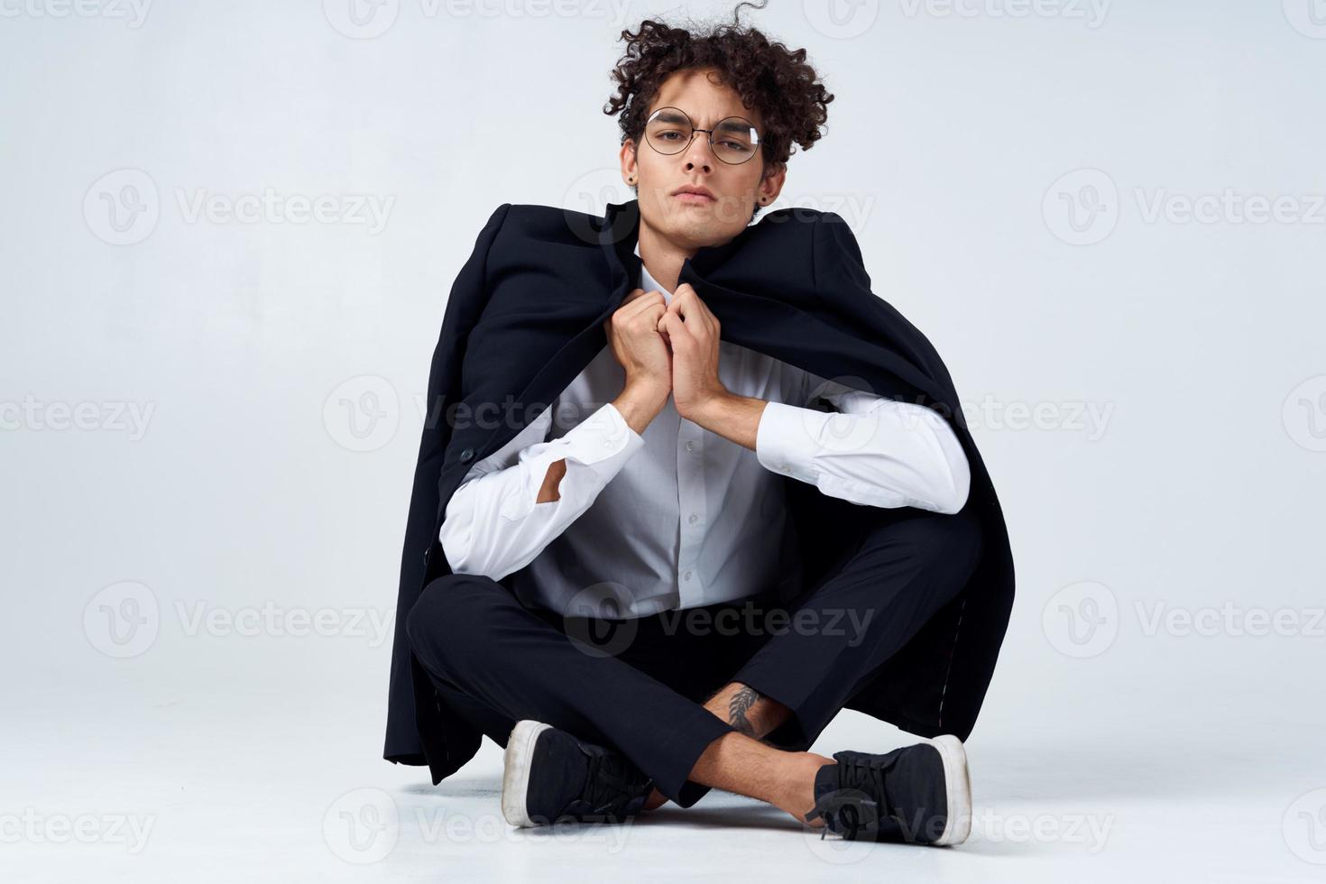 alegre chico en un clásico traje con un chaqueta en su espalda y gesticulando con su manos Copiar espacio zapatillas foto