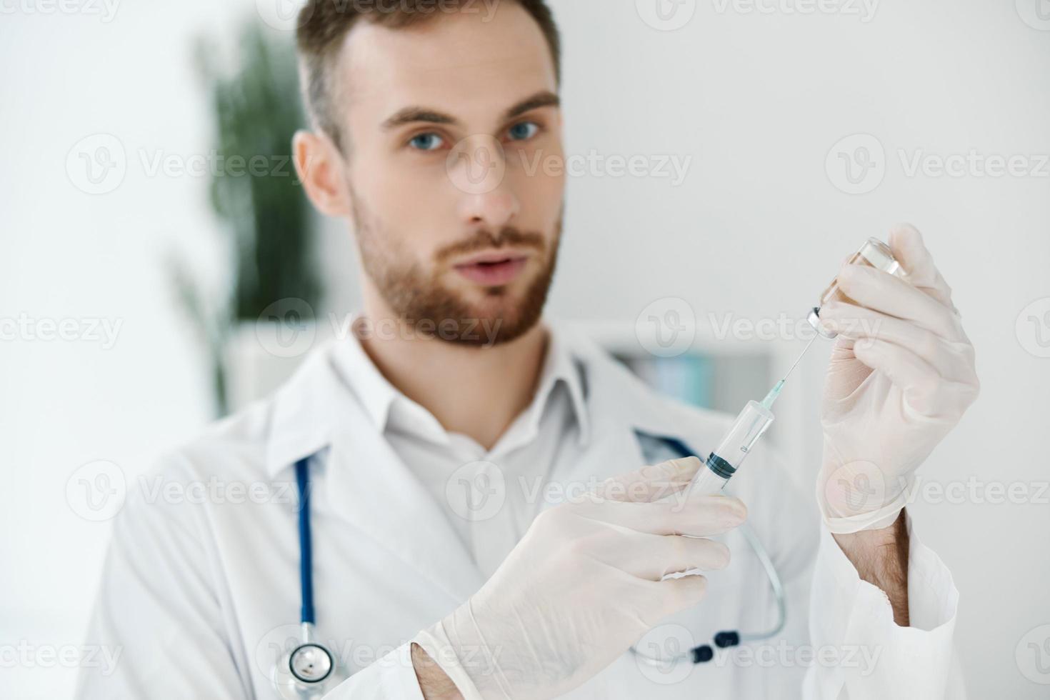 médico con líquido en ampolla jeringuilla desarrollo vacunación y y protector guantes foto