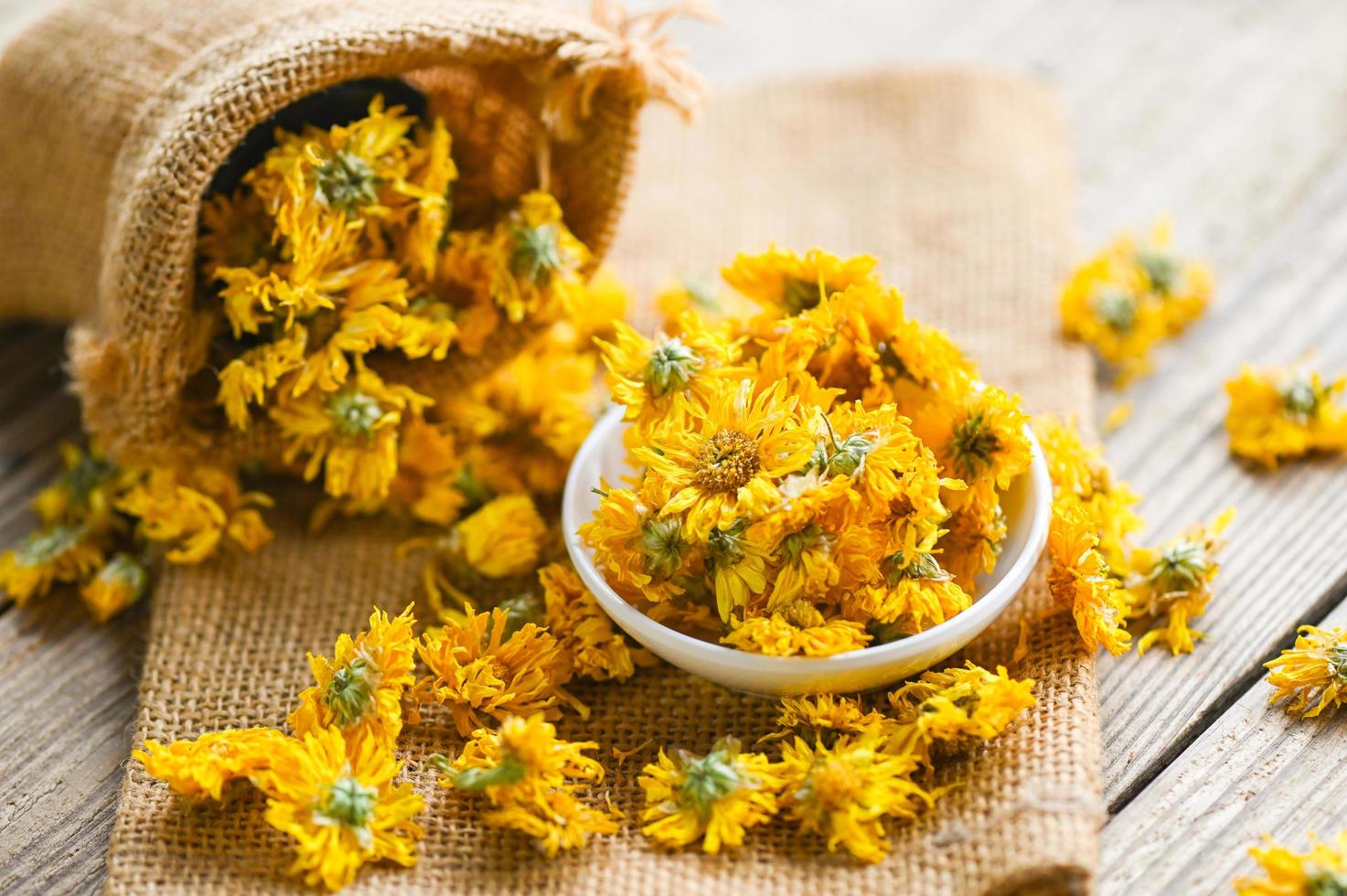 Chinese chrysanthemum flower tea - Dried chrysanthemum buds for herbal tea on wooden background, dry chrysanthemum flower yellow photo