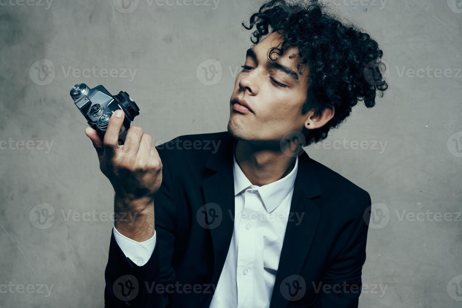 photographer with camera indoors on gray background and jacket curls shirt model photo