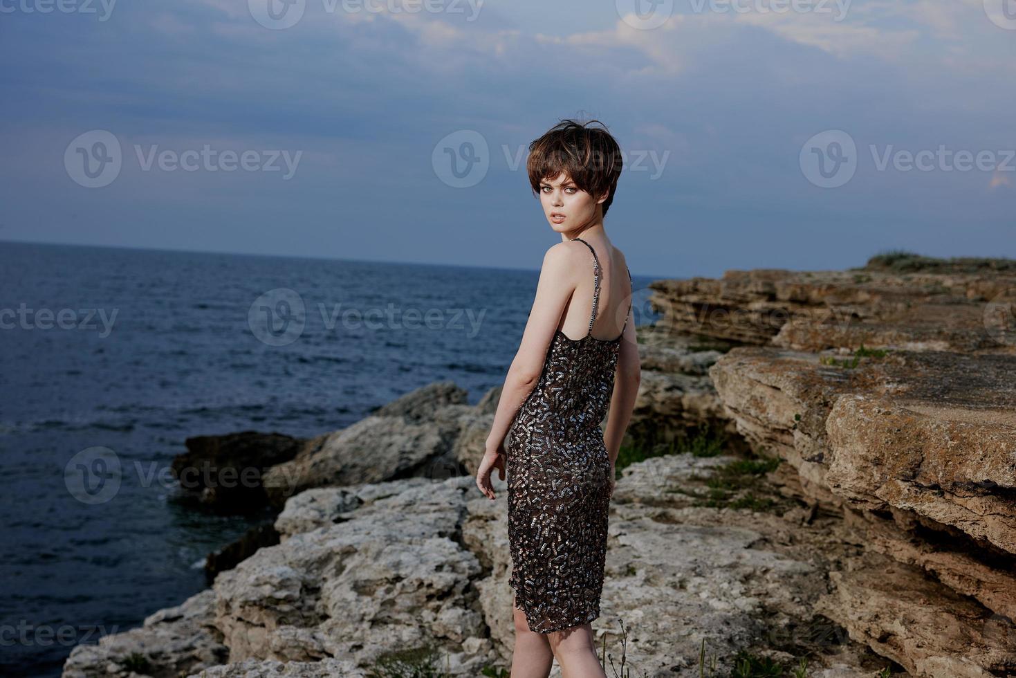 pretty woman in dress on nature rocks landscape elegance photo