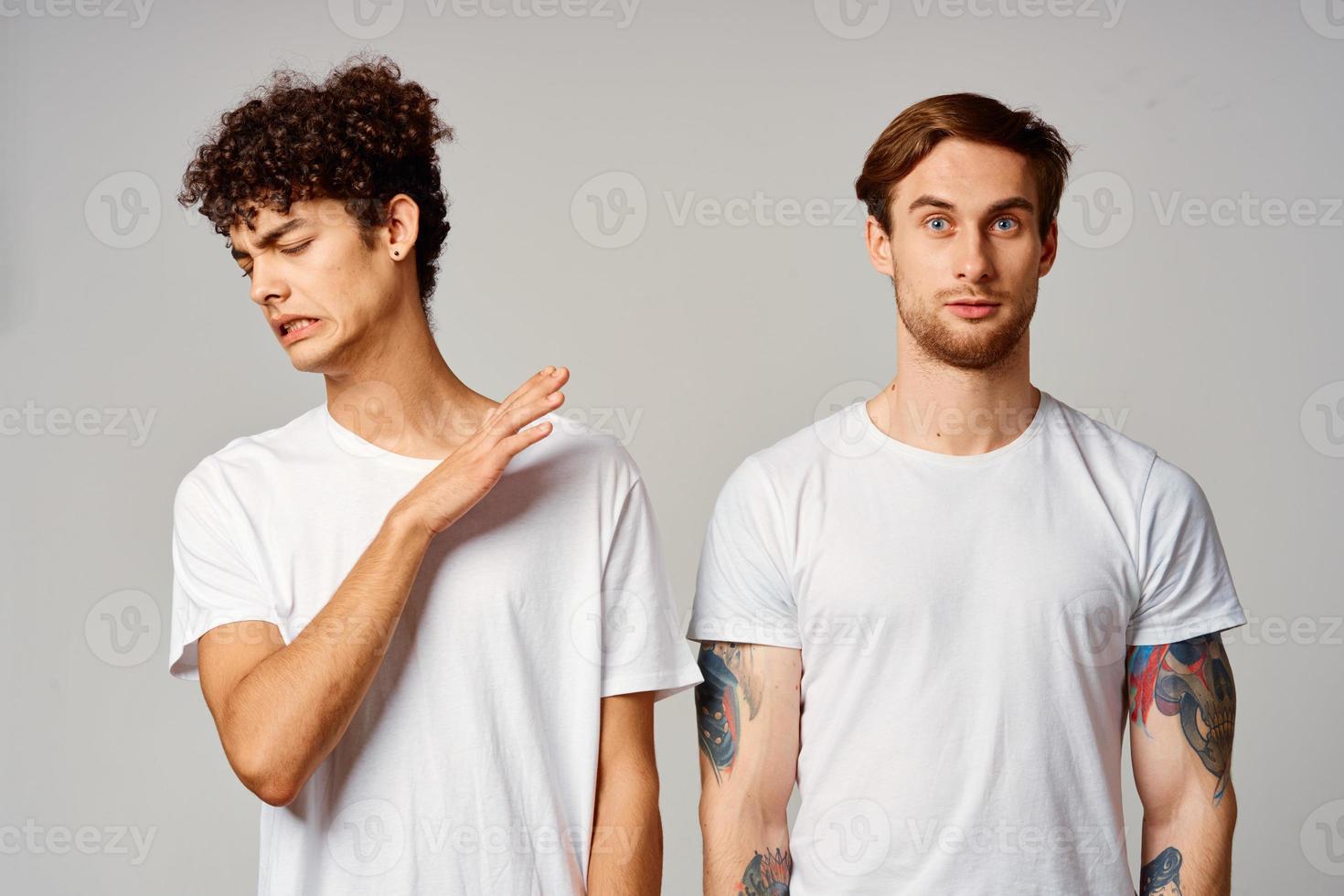 Two cheerful friends in t-shirts stand side by side isolated background joy photo