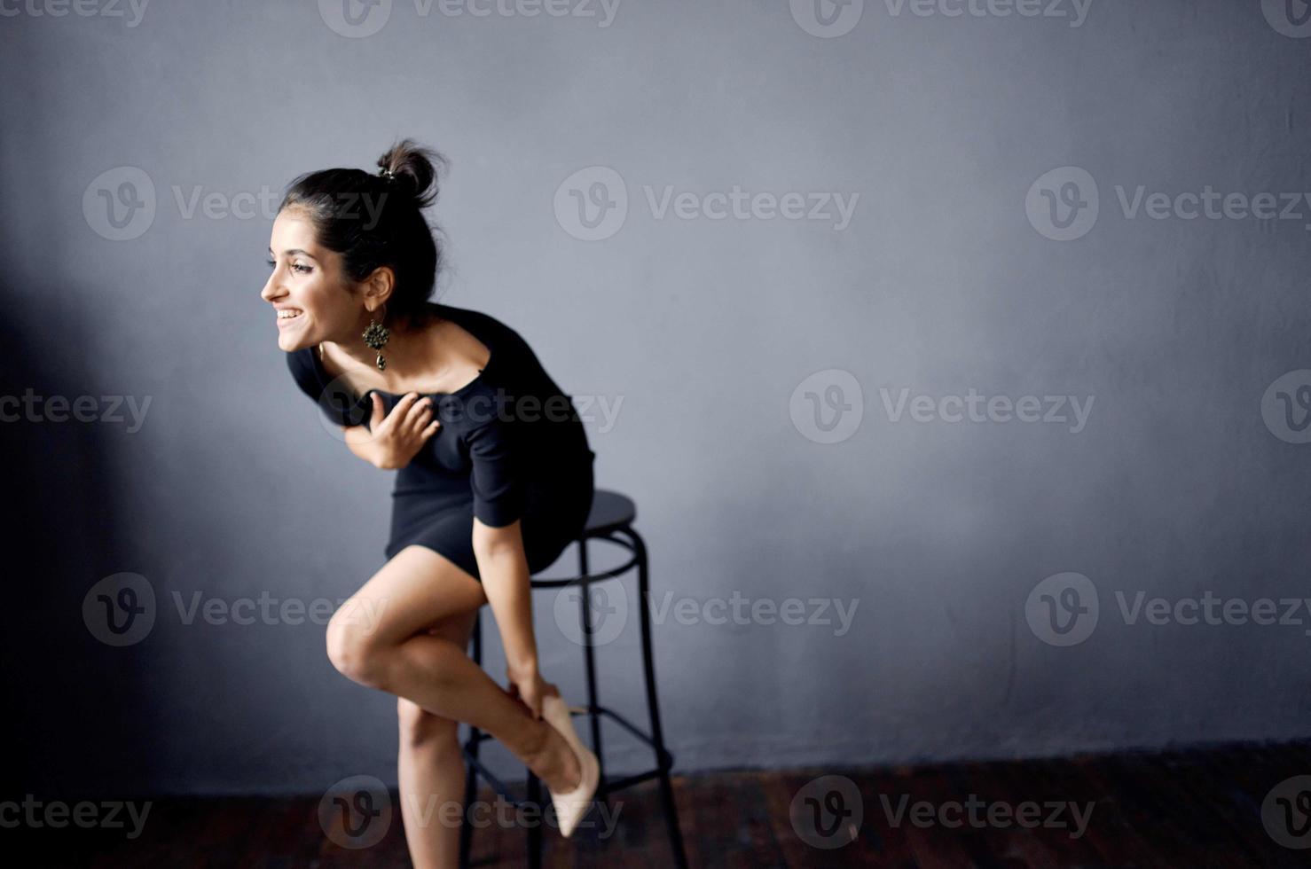 bonito mujer en un negro vestir lujo Moda oscuro antecedentes foto