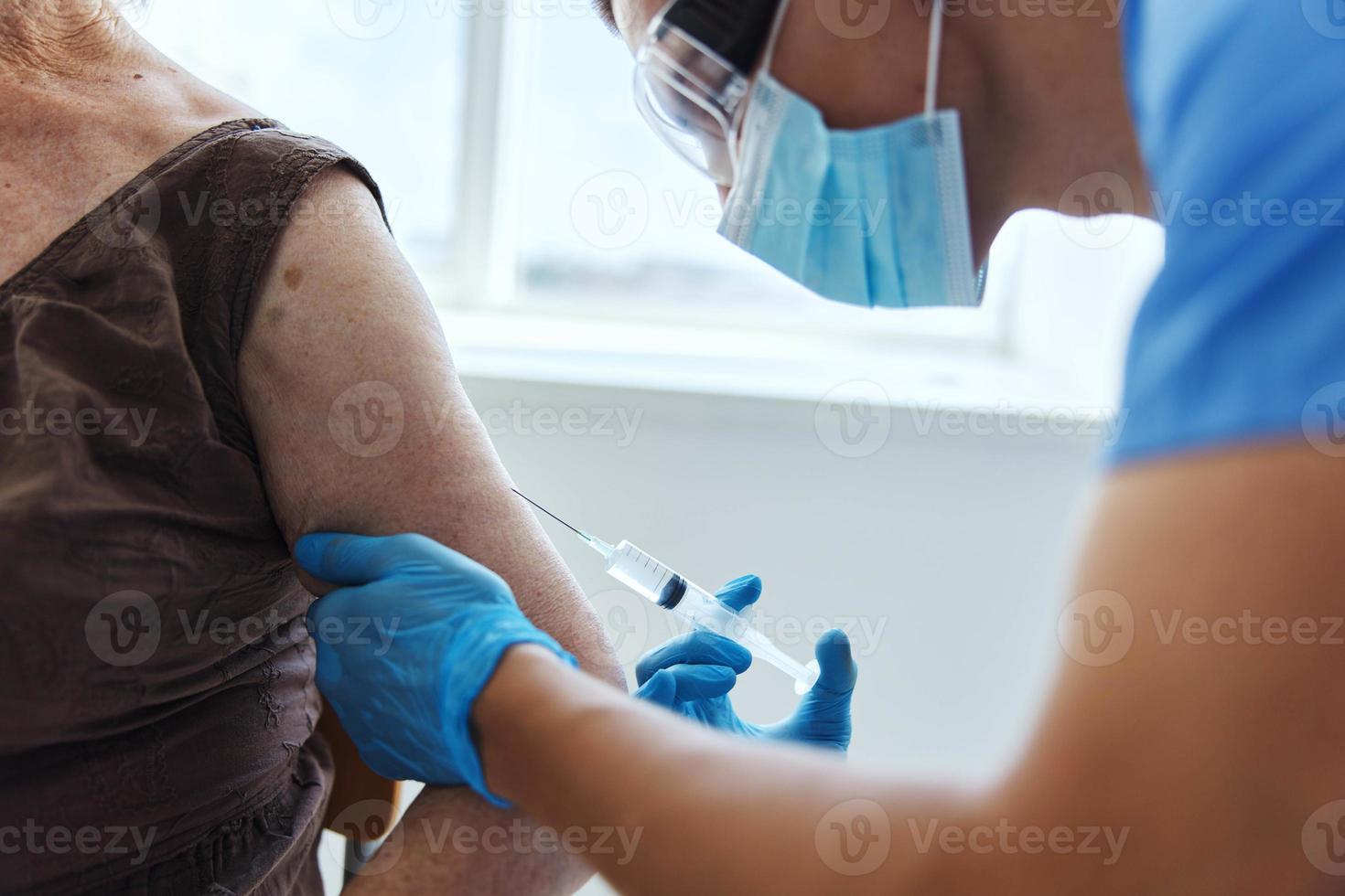 doctor with a syringe covid-19 passport in medical masks photo