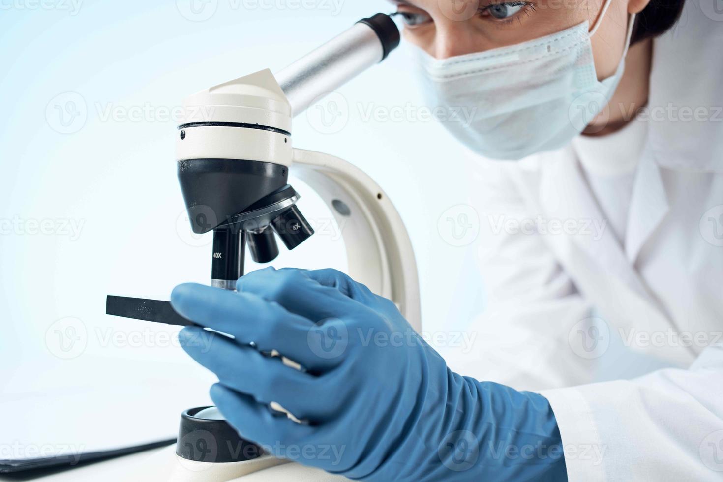 laboratory assistant wearing a medical mask looking through a microscope Professional research experiment photo