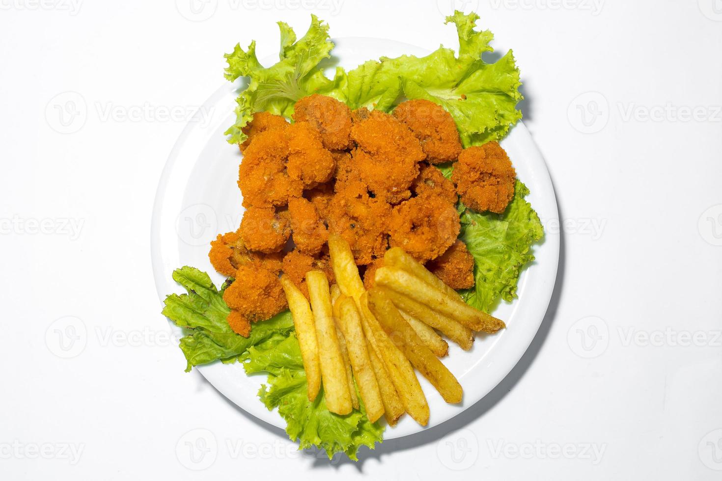 Fresh calamari with french fries in a plate. Healthy sea food squid fry, potato fries and lettuce meal on white background photo