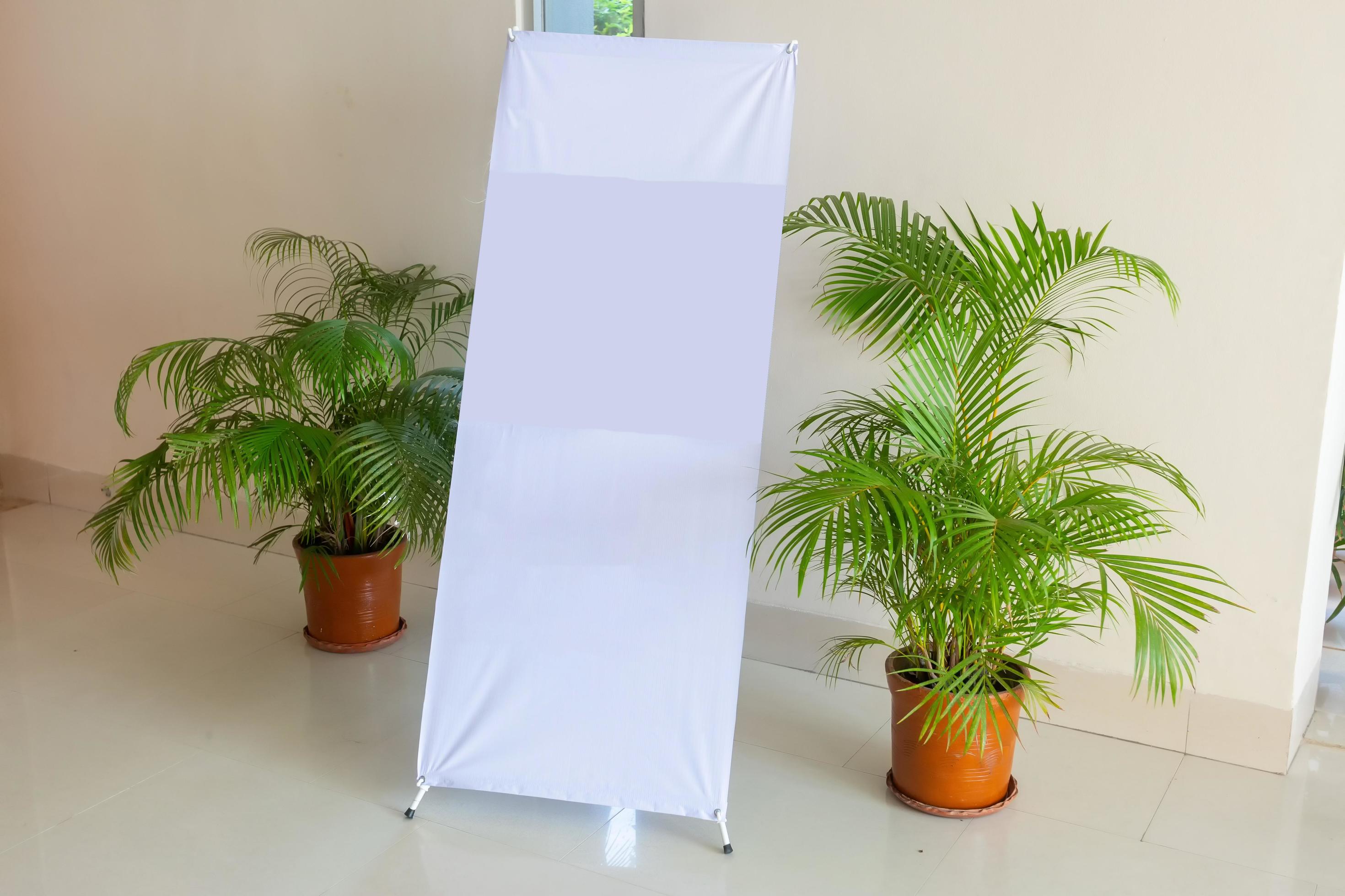 A white blank design display X-Stand on an indoor wall side. A Blank
