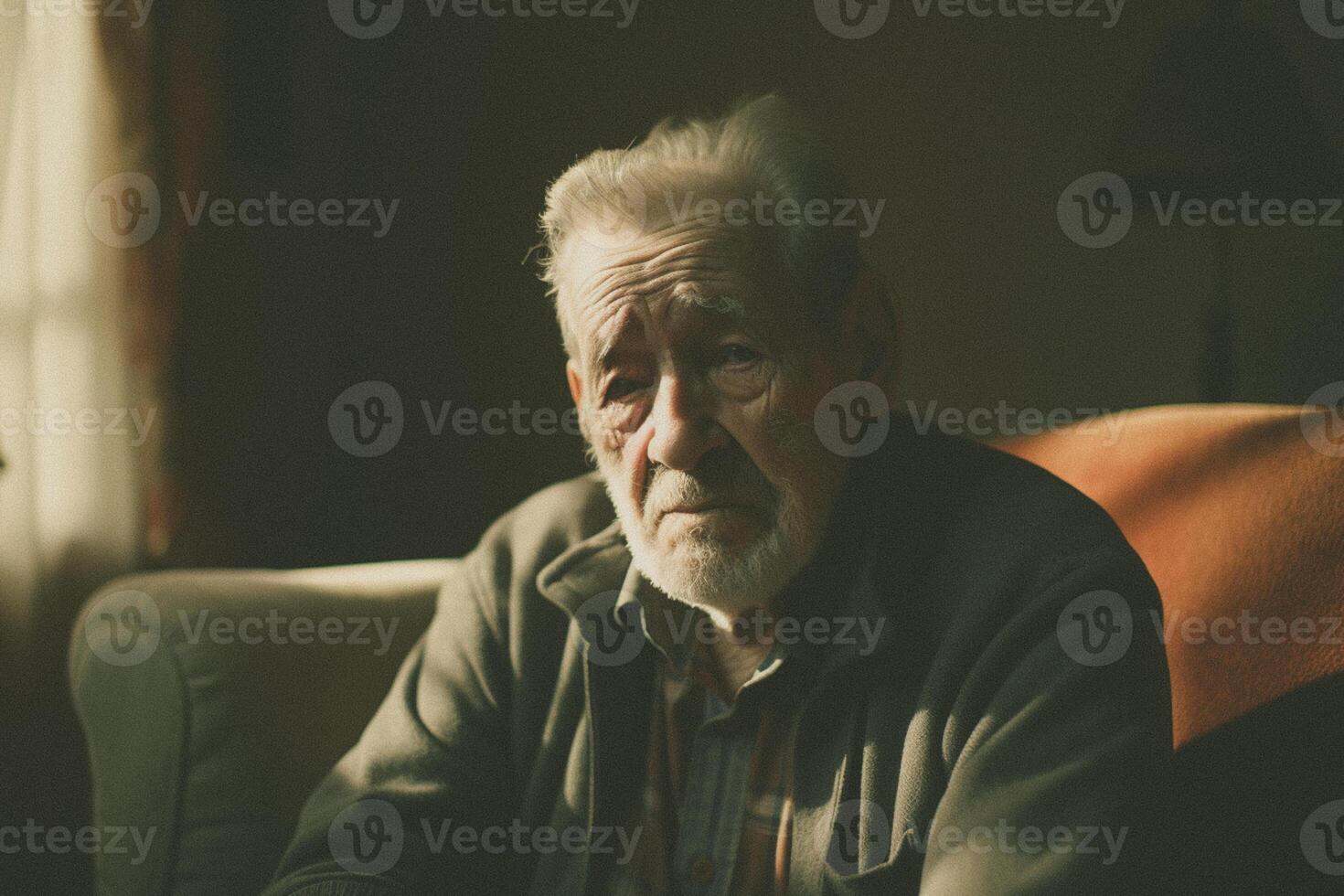 Senior grandfather sitting in the living room on the sofa couch, feeling nostalgic, pain, missing his grandchildren, bankruptcy, and fraud at home. photo