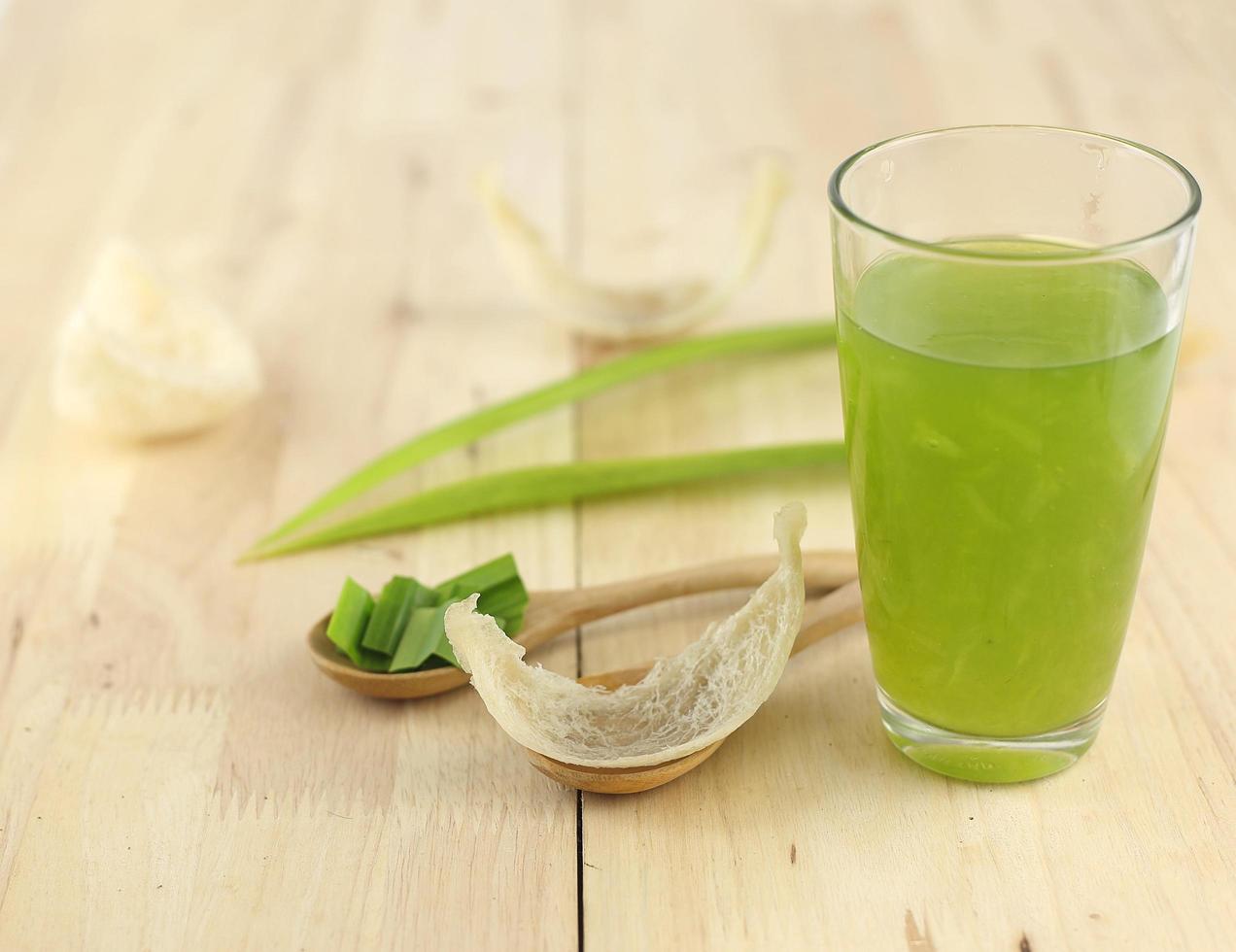 Glass of swallow nest soup with pandan on wooden table photo