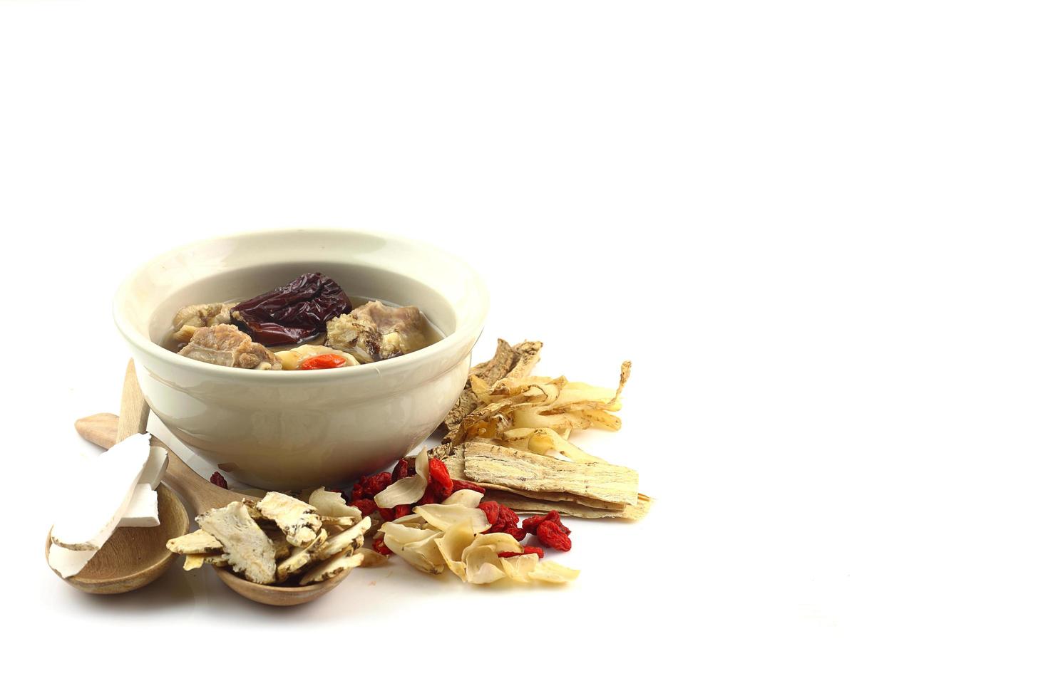 Pork soup with Chinese medicine on white photo