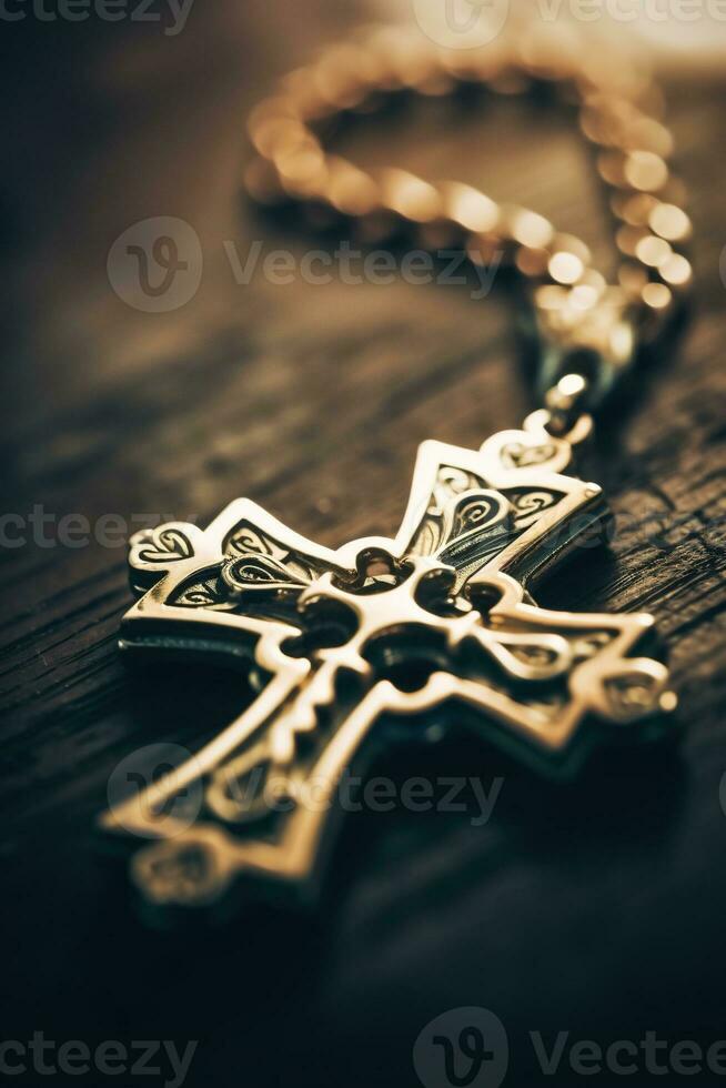 Close-up of a silver cross on a wooden table, shallow depth of field photo