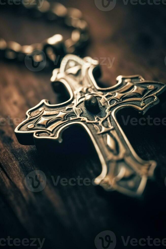 Close-up of a silver cross on a wooden table, shallow depth of field photo