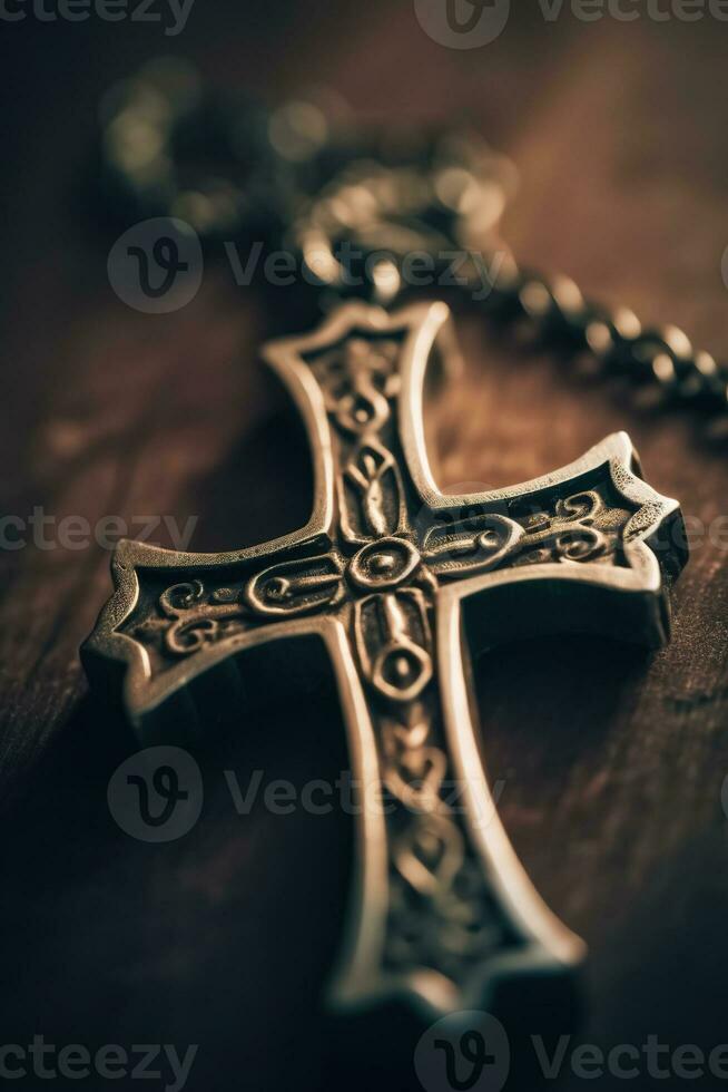 Close-up of a silver cross on a wooden table, shallow depth of field photo