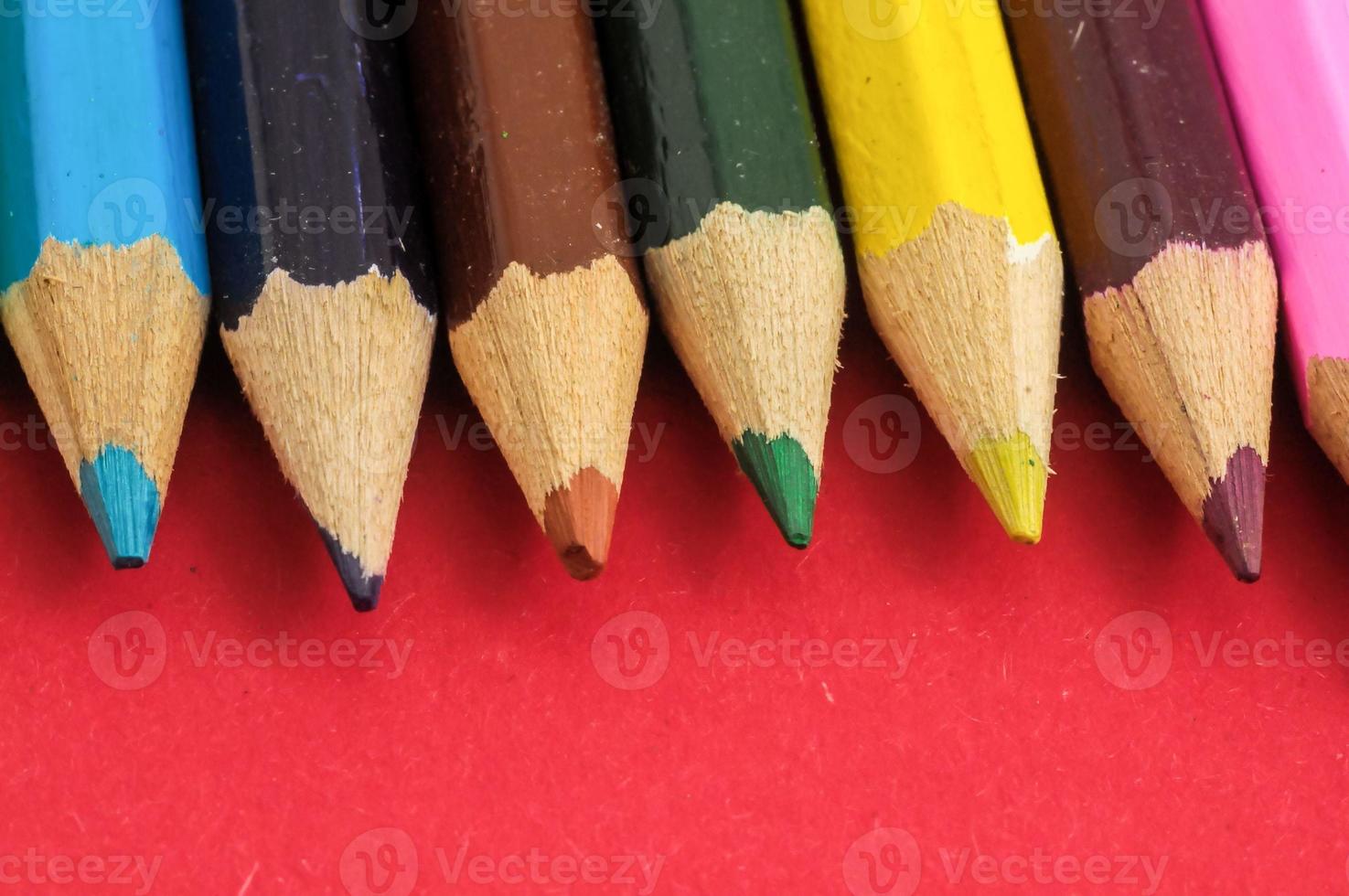 Colorful pencils on red background photo