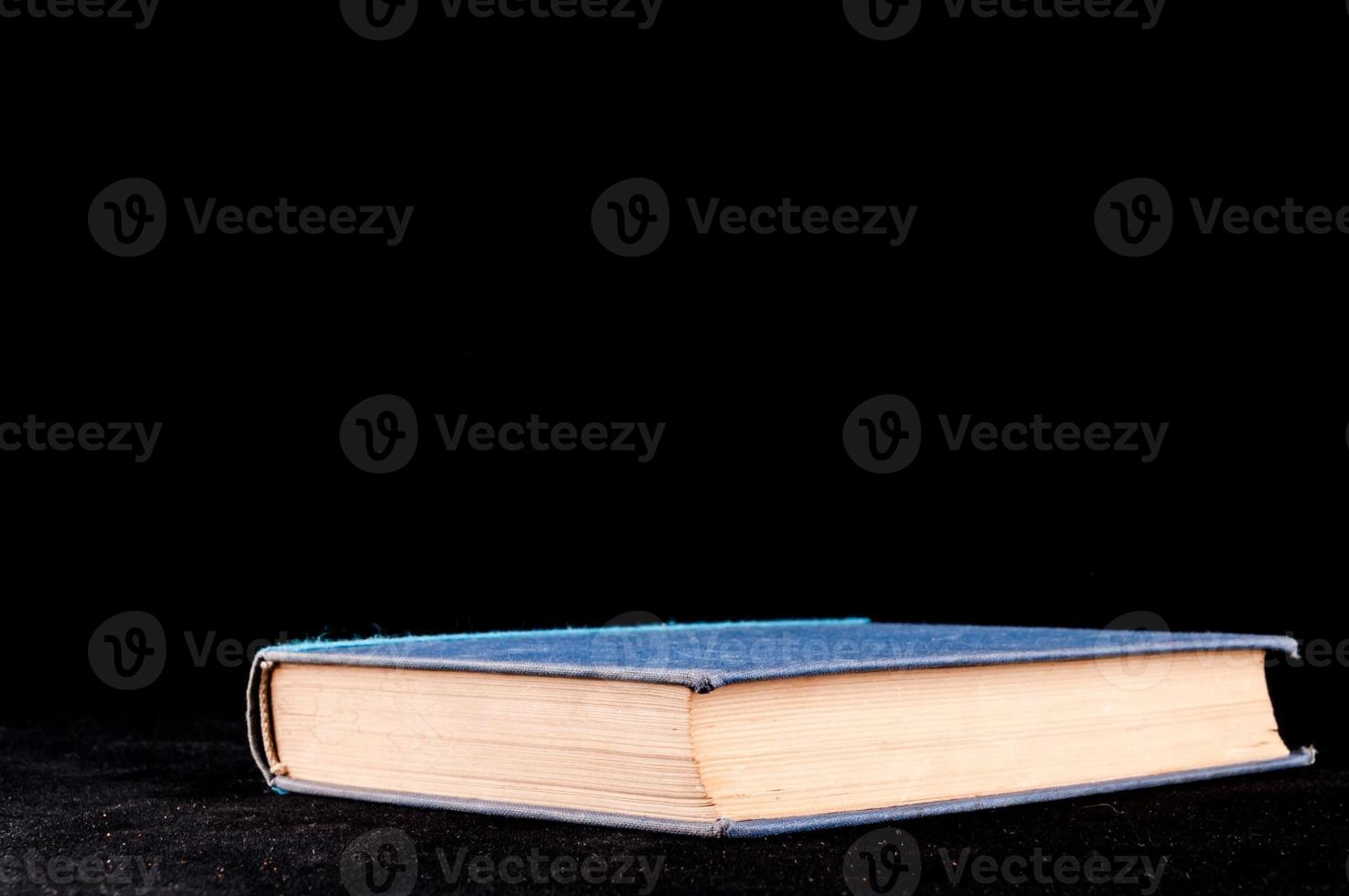 Blue book on black background photo