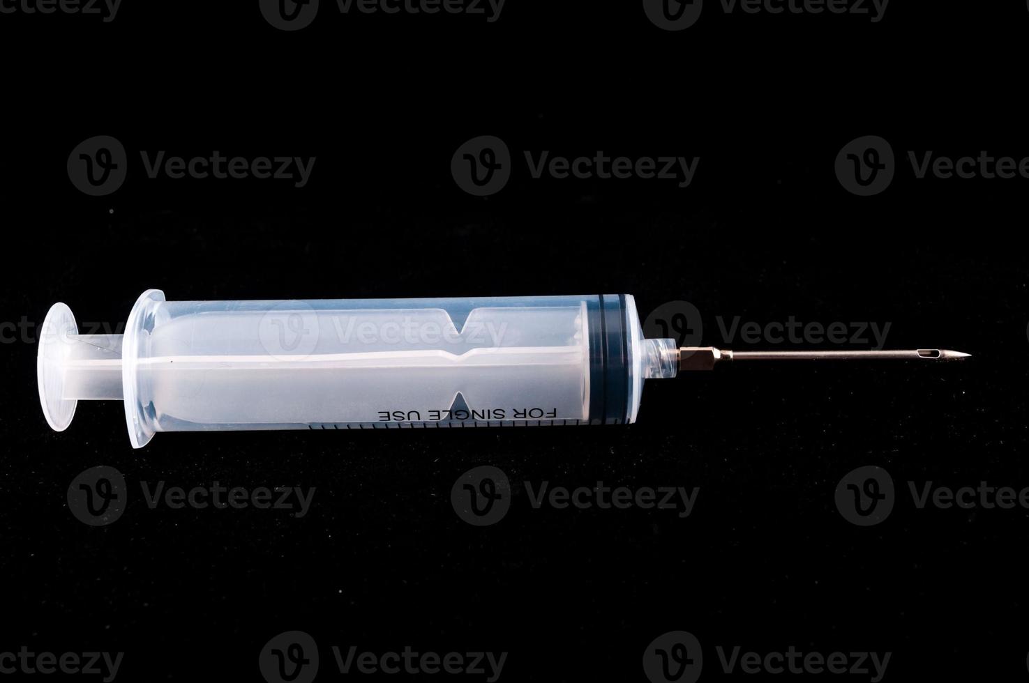 A syringe on black background photo