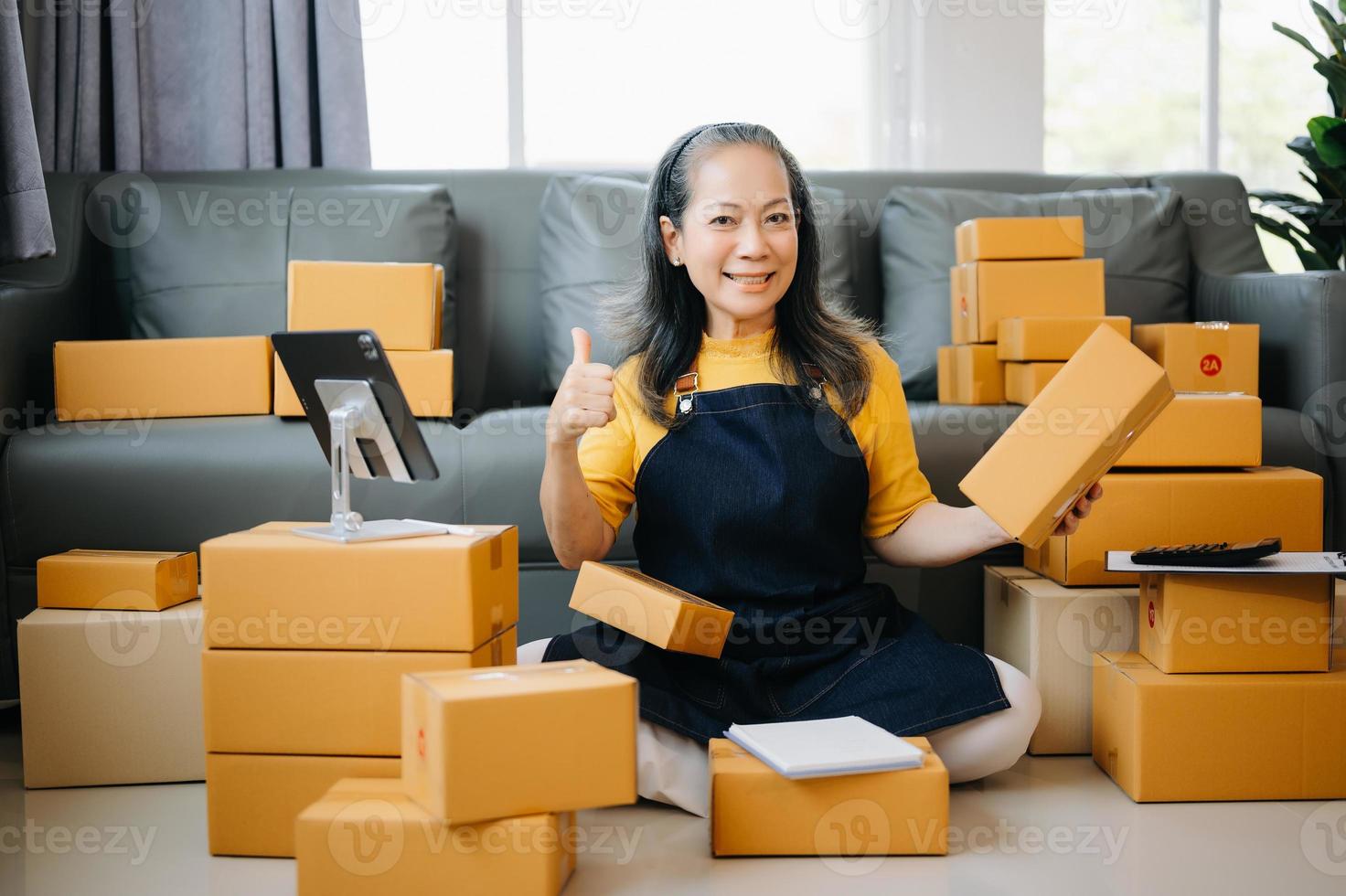 pequeño negocio empresario SME Lanza libre mayor mujer trabajando a oficina, caja, tableta y ordenador portátil en línea, marketing, embalaje, entrega, comercio electrónico concepto foto