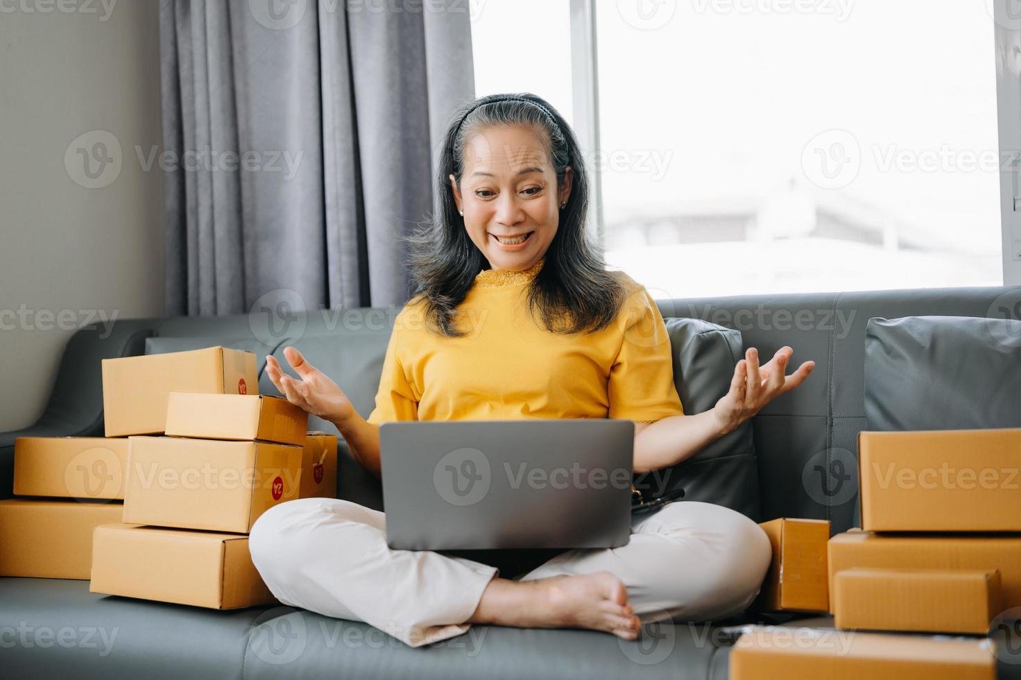 Senior business owner woman prepare parcel box and standing check online orders for deliver to customer on tablet, laptop Shopping Online concept. photo