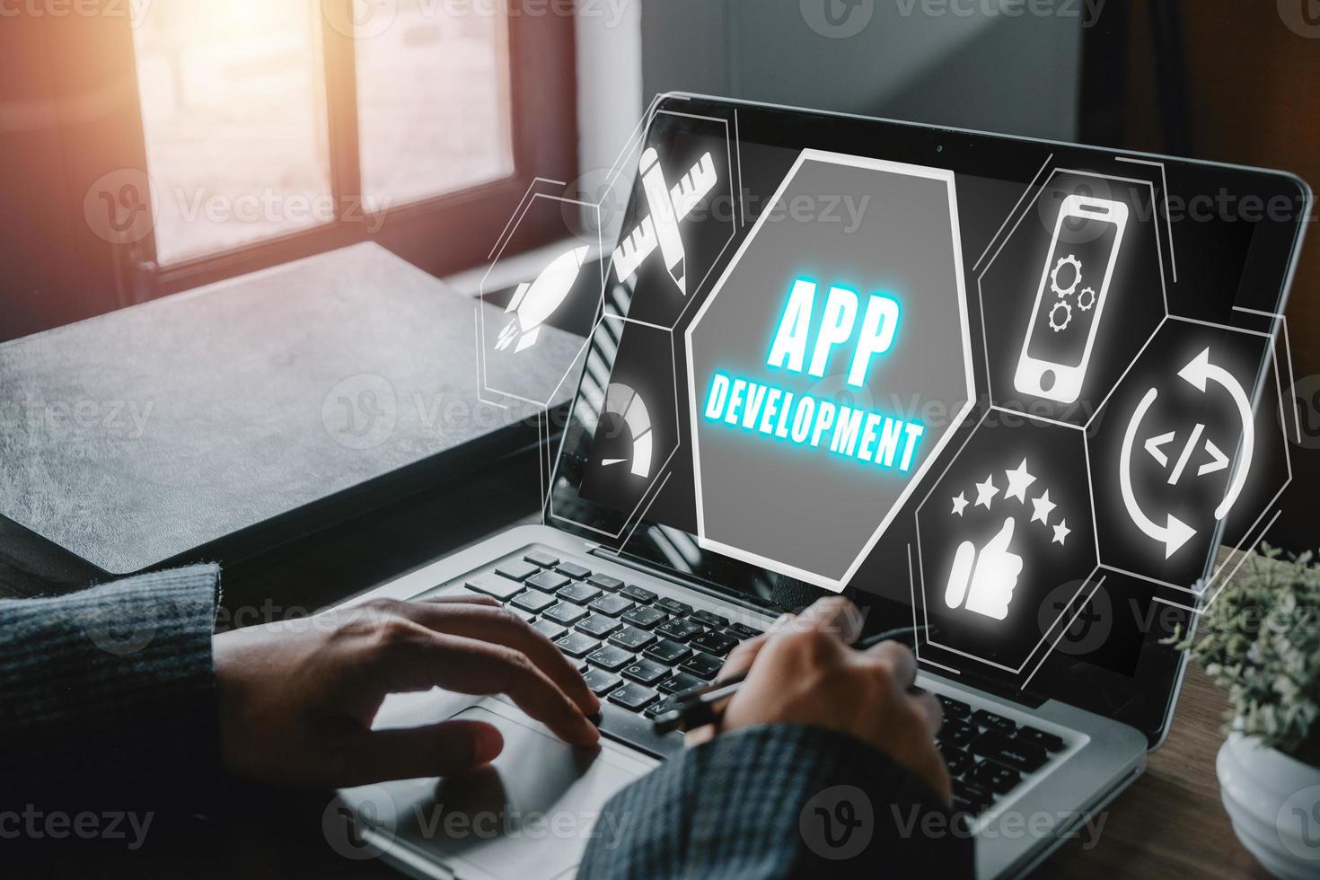 App development concept, Person hand using laptop computer with app development icon on virtual screen background, Designing application for mobile phone. photo
