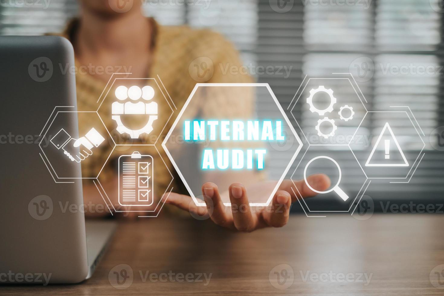 Internal audit concept, Person working on laptop computer and hand holding internal audit icon on virtual screen. photo