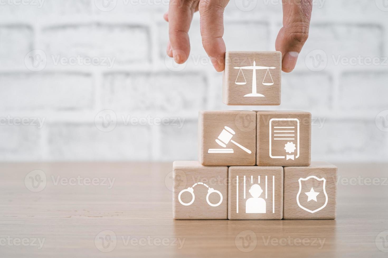 Person hand holding law icon on wooden cube with copy space, terrorism, crime, judgment, verdict, justice and law concept photo