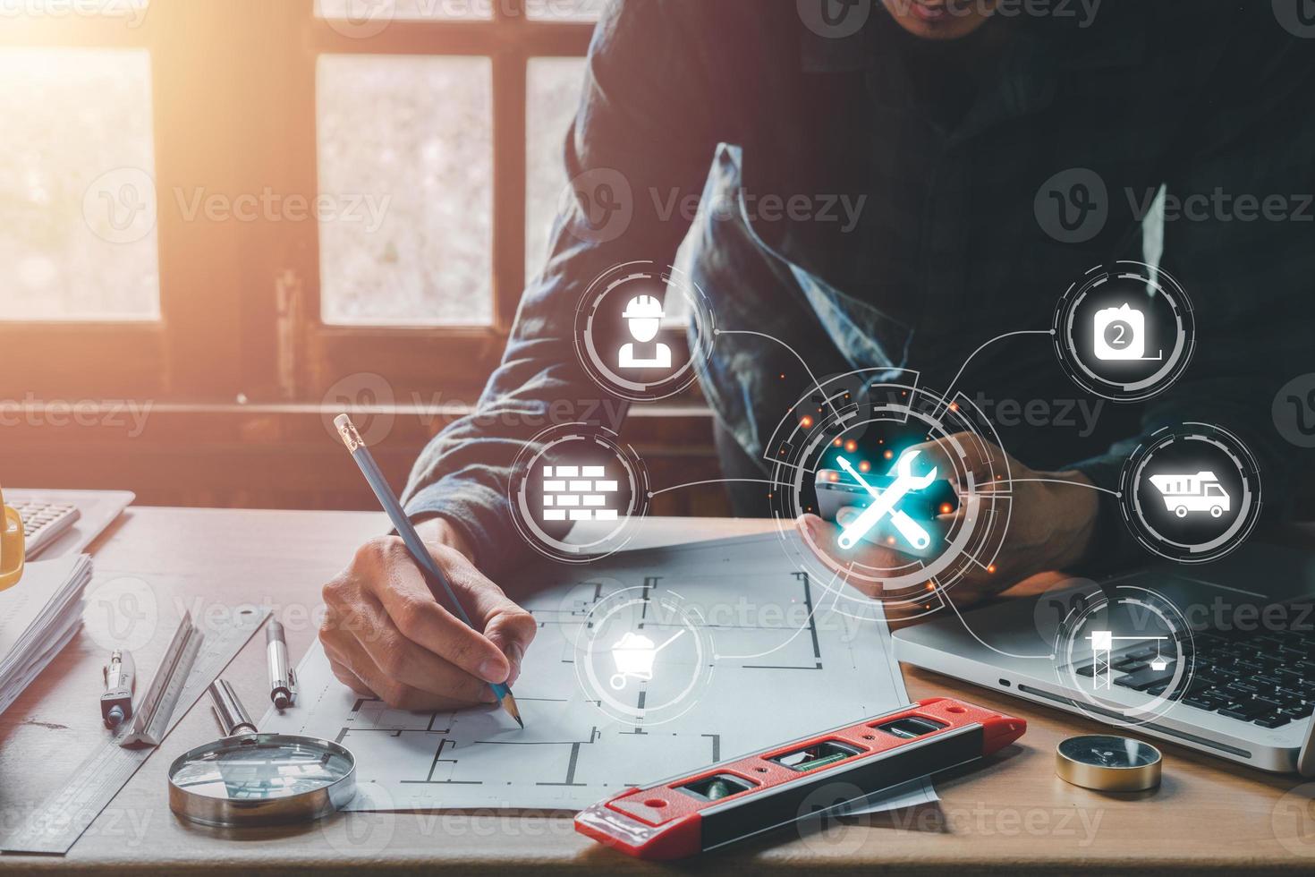 Construction concept, Engineer person working on laptop computer and hand pointing with VR screen building icon, blueprint and building model. photo