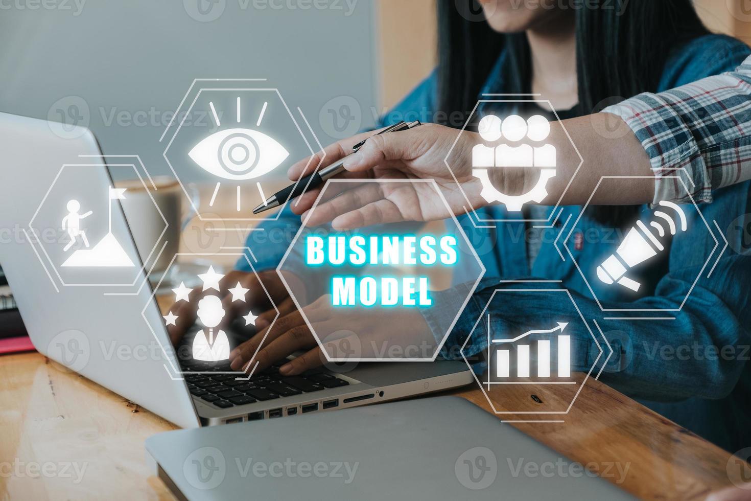 Business model and planning project concepts, Two business colleagues discussing data on desk with business model icon on virtual screen. photo