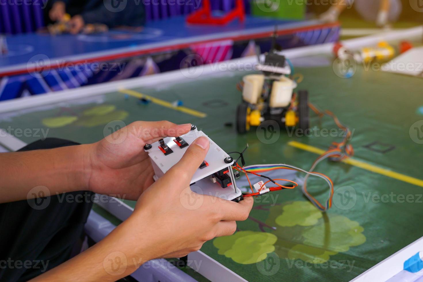Asian high school students practice moving robots on the playing field To perform missions according to the rules of the robot competition. Soft and selective focus. photo